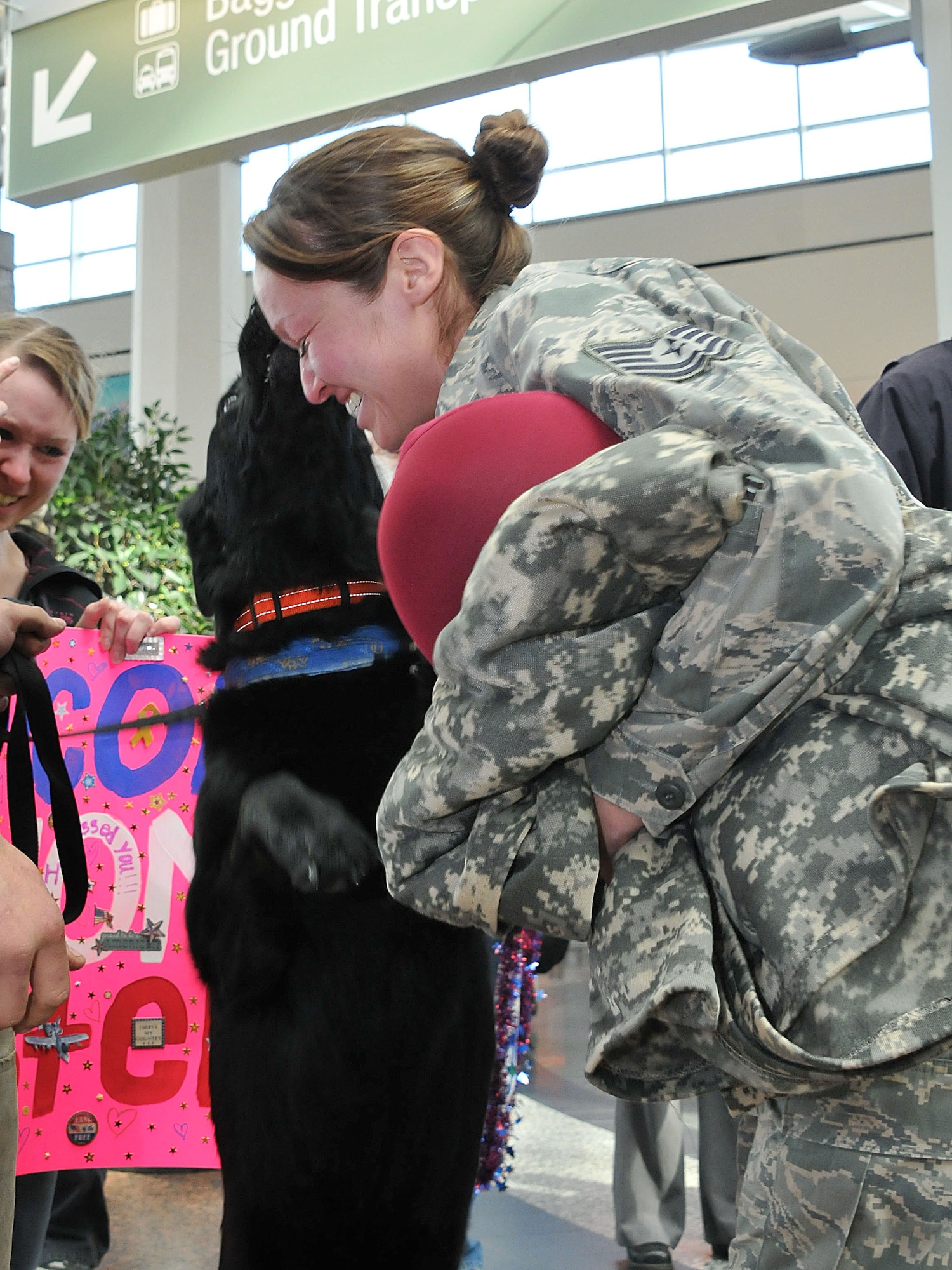 ANCHORAGE, Alaska -- Tech. Sgt.Abigail Olivares, a utilities technician from the 176 Civil Engineer Squadron, is greeted by her pet dog at Ted Stevens International Airport here as she returns from deployment with a few of her commrades. Olivares was assigned to the 386 Expeditionary Civil Engineer Squadron for a six-month tour in Southwest Asia. National Guard Photo by Staff Sgt. N. Alicia Goldberger.