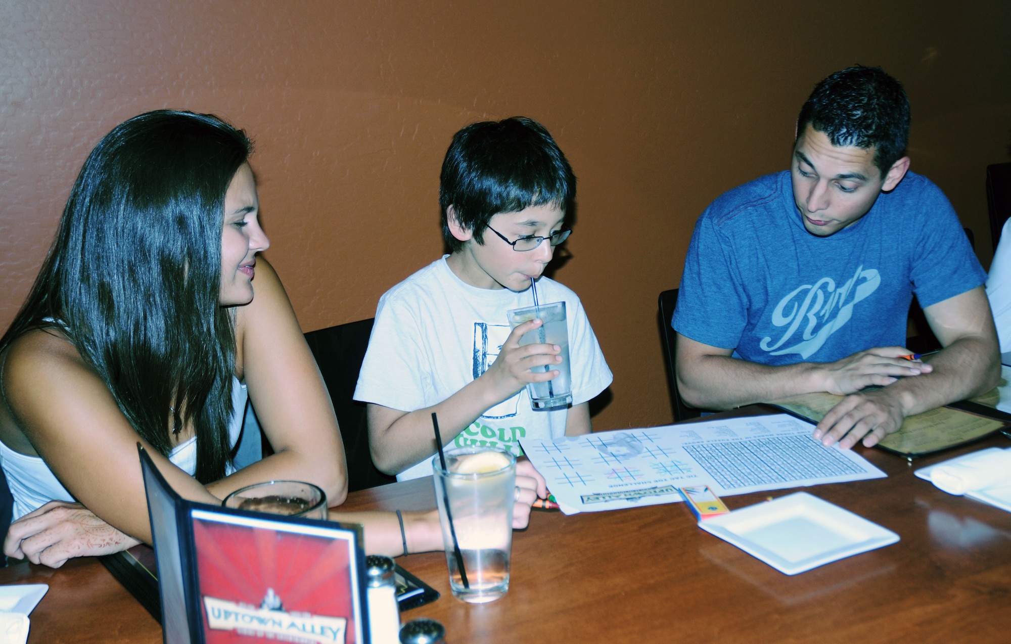 Staff Sgt Angel Mariscal, 944th Logistics Readiness Squadron, enjoys a little tic-tac-toe with his family before dinner at Uptown Alley in Surprise Ariz.  Mariscal was one of three Airmen treated to a special Father’s Day event celebrating military dads.  (U.S. Air Force photo/Capt. Elizabeth Magnusson)