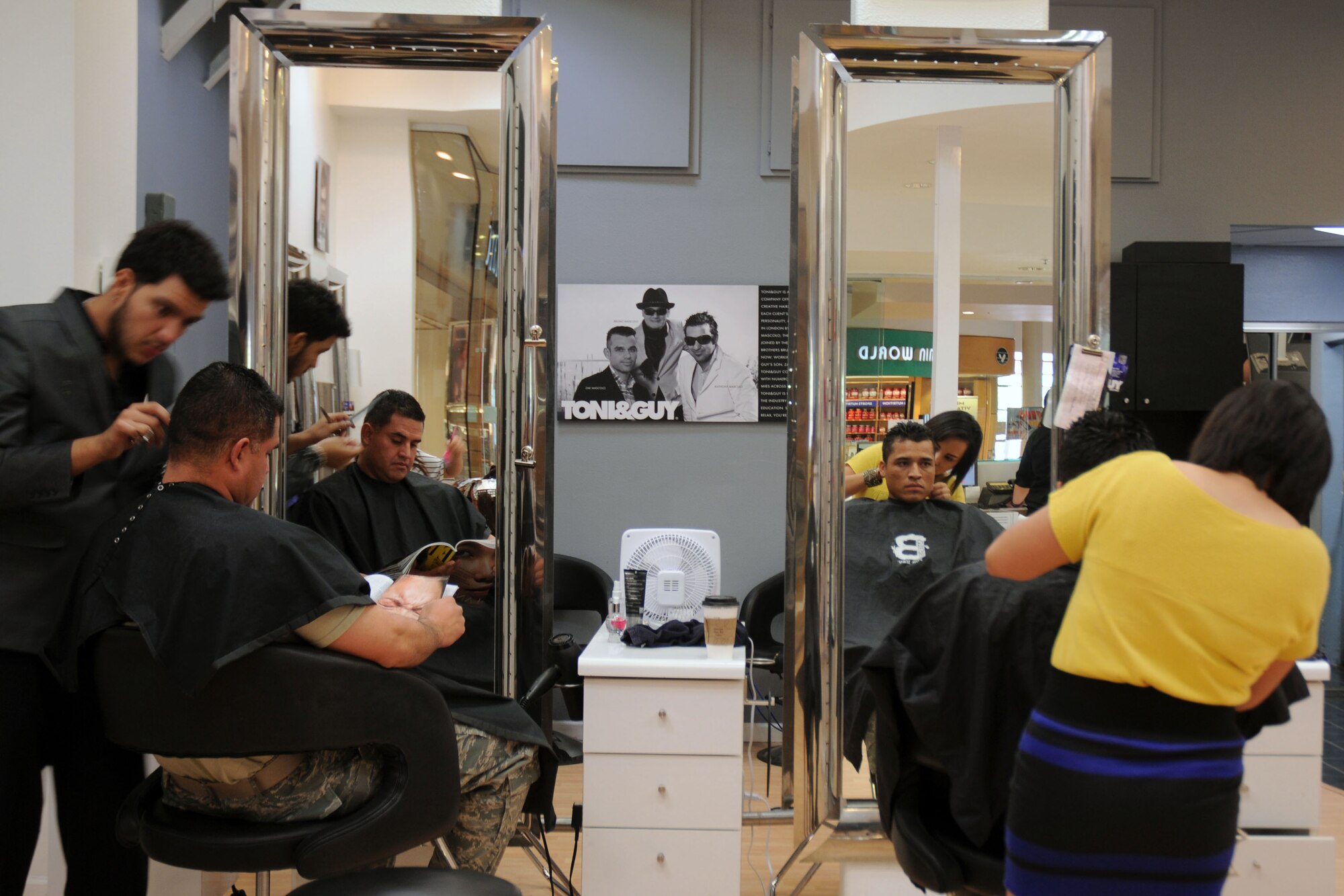 Staff Sgts. Kevin Semallie, 944th Civil Engineer Squadron, and Louis Vega Jr., 944th Fighter Wing, receive haircuts as part of a Father’s Day event celebrating military dads.  In a show of support for the military and their families three Phoenix area businesses teamed up to celebrate dads in uniform on Father’s Day. Toni and Guy Salon, Dillard’s Department Store, and Uptown Alley, an entertainment complex and full service restaurant, treated three Airmen to a special celebration Sunday. (U.S. Air Force photo/Capt. Elizabeth Magnusson)