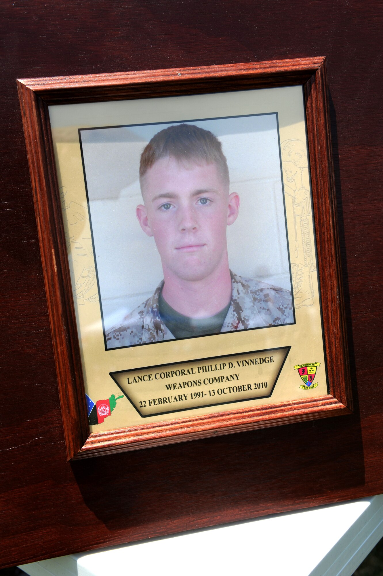 A photo of fallen Lance Cpl. Phillip Vinnedge stands on outside the Fallen Hero's Dream Ride truck display at the base wide picnic on Scott Air Force Base, Ill. June 15 , 2012. Fallen Hero's Dream Ride was formed by Cory Vinnedge after the death of his brother Lance Cpl. Phillip Vinnedge who was killied in action while serving in Afghanistan. The goal of Fallen Hero's Dream ride is to create a rolling memorial to build awareness of the sacrifices our fallen military men and women have made, and to encourage support of related not for profit organizations. (U.S. Air Force photo/2nd Lt. Korey Fratini)