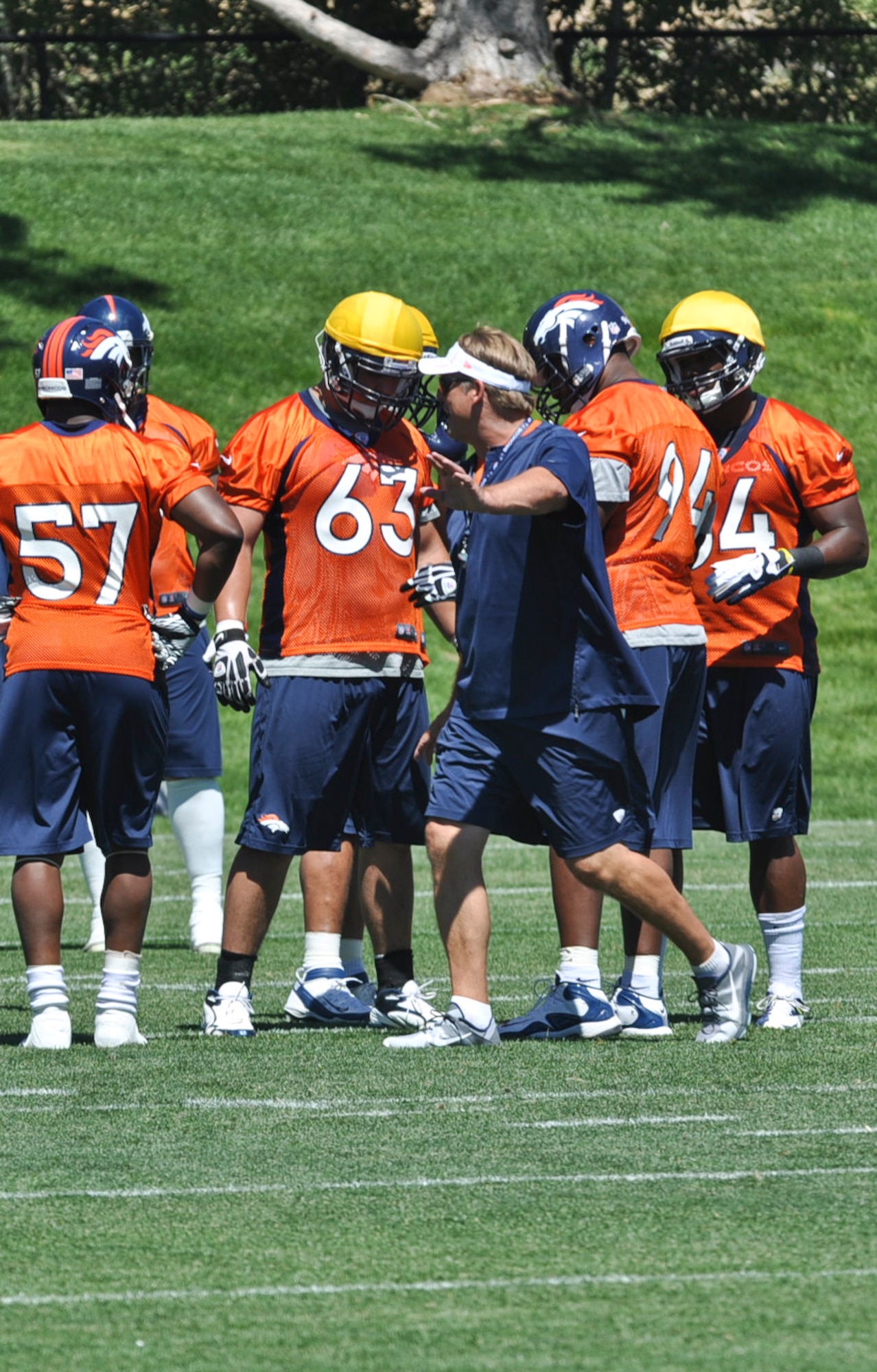 ENGLEWOOD, Colo. – Benjamin Garland, along with other Denver Bronco teammates, receives advice from a coach during a mini-camp session June 13, 2012. Garland, a Grand Junction, Colo. native, not only plays professional football, but is also assigned to the  140 Wing Public Affairs Office, Colorado Air National Guard. (U.S. Air Force photo by Senior Airman Christopher Gross)