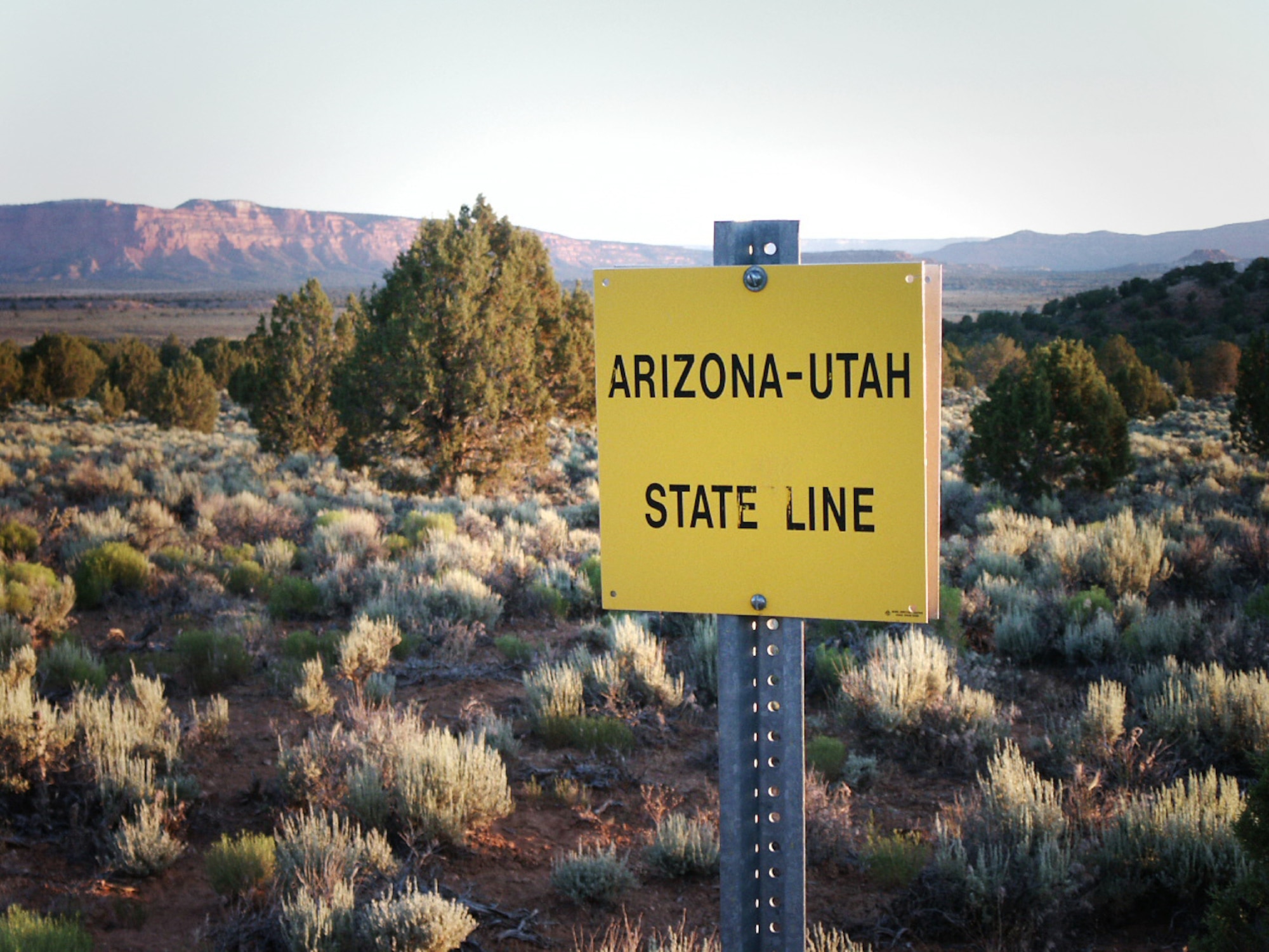 Jette Carr and Jon Warnick take a picture of the Arizona-Utah state line, the starting point in their walk across the state, summer of 2003. The hike was part of a trek spanning from the bottom to the top of Utah to each boarder – a journey that took 43 days and was nearly 700 miles long.  (Courtesy photo)