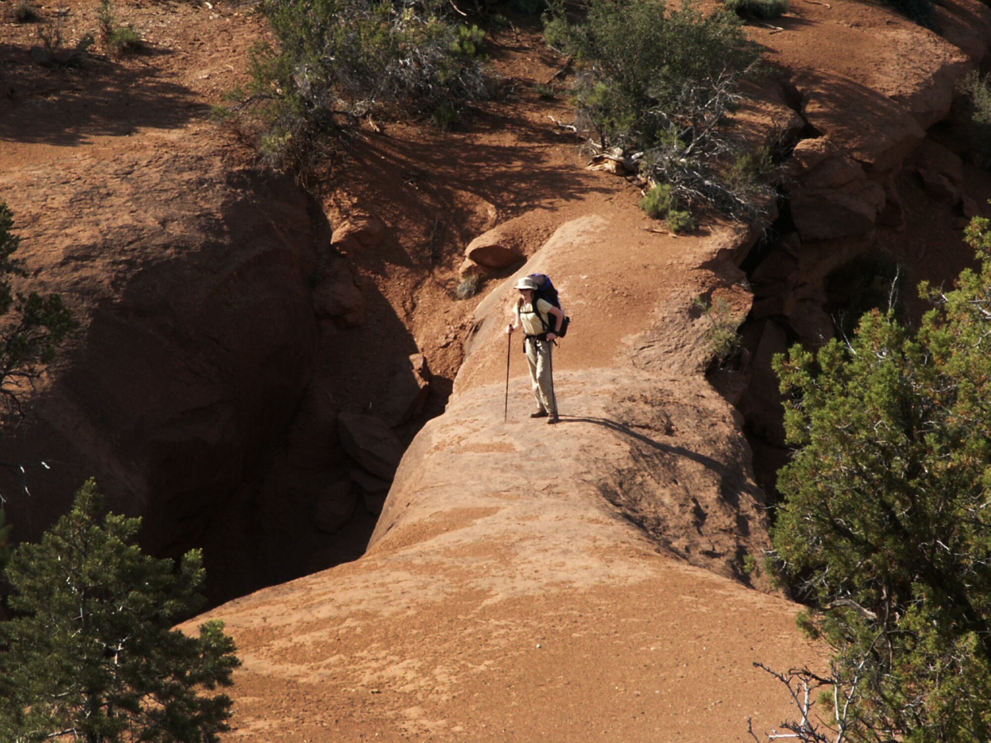 Jette Carr crosses a natural arch in southern Utah during the first day in a walk across the state, summer of 2003.  The hike was part of a trek spanning from the bottom to the top of Utah to each boarder – a journey that took 43 days and was nearly 700 miles long.  (Courtesy photo)
