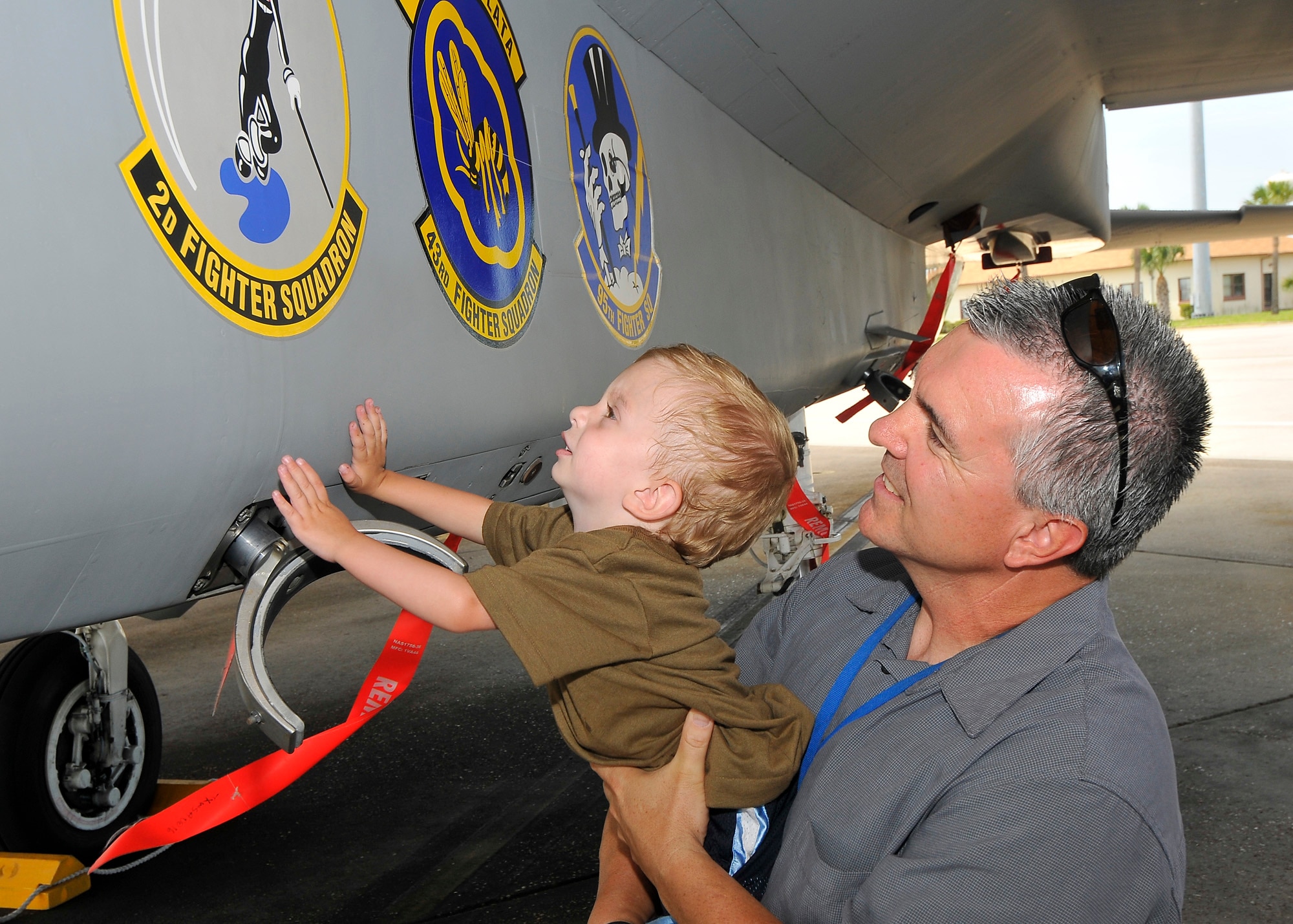 Kevin Sallaway, a nurse at the 325th Medical Group Family Practice clinic, holds up his grandson, Jaxon, as they explore a F-15 Eagle during Jaxson's tour of Tyndall. (U.S. Air Force photo by Chris Cokeing)