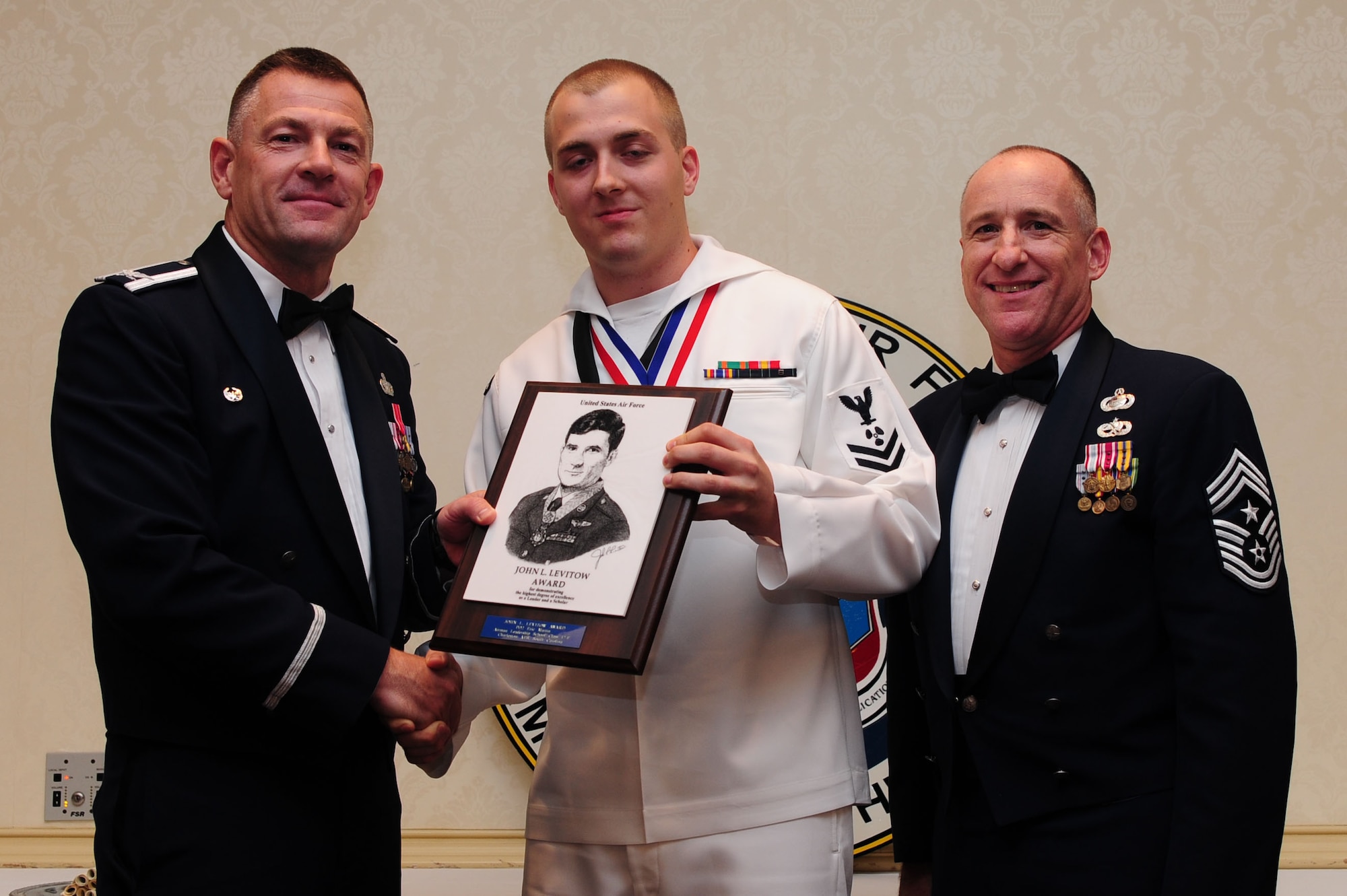 Col. Richard McComb, Joint Base Charleston commander and Chief Master Sgt. Earl Hannon, 628th Air Base Wing command chief present the John L. Levitow Award to Petty Officer 2nd Class Eric Martin during the Airman Leadership School Class graduation June 14, 2012 at Joint Base Charleston - Air Base. Pa. Martin is a machinist’s mate assigned to the 628th Security Forces Squadron Information Protection office at Joint Base Charleston – Weapons Station. The Levitow award is given for a student's exemplary demonstration of excellence, both as a leader and a scholar. (U.S. Air Force photo/ Airman 1st Class Chacarra Walker)