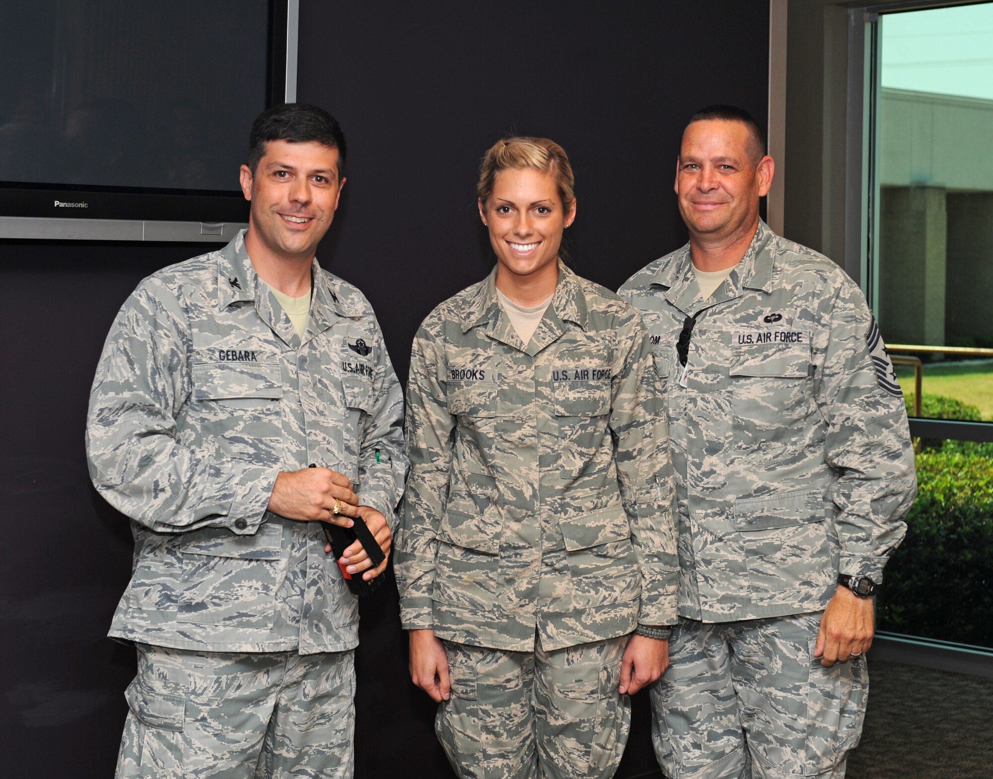 Senior Airman Bryenna Brooks poses with Col. Andrew Gebara, 2nd Bomb Wing commander, and Chief Master Sgt. Larry Malcom, 2 BW command chief, after being told recently she was named one of the Air Force's 12 Outstanding Airmen of the Year for 2012.  Brooks is a member of the 2nd Medical Operations Squadron at Barksdale Air Force Base, La.  The award recognizes 12 outstanding Air Force enlisted members for superior leadership, job performance, community involvement and personal achievements.  The program was initiated at the Air Force Association's annual national conference in New Orleans in 1956. The selection board consists of the Chief Master Sergeant of the Air Force, selected major-command command chiefs and a general officer. The selections are then reviewed by the Air Force Chief of Staff.  In addition to being awarded the Outstanding Airman ribbon with the bronze star device, and being able to wear the Outstanding Airman badge for one year, Brooks will also have the opportunity to serve on the Air Force Enlisted Council for one year, representing Team Barksdale and helping shape the future of the Air Force, according to the AFA website.  The AFA will honor the 12 Outstanding Airmen of the Year at an event in Washington, D.C., Sept. 15 to 20.  (U.S. Air Force photo/Airman 1st Class Benjamin Gonsier)(RELEASED)
