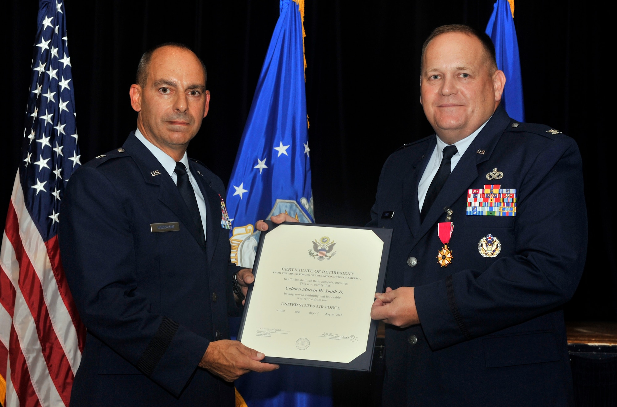 U.S. Air Force Brig. Gen. Jeffery Harrigian, U.S. Air Force Central assistant deputy commander, hands Col. Marvin Smith, U.S. AFCENT A7 director of installations, his certificate of retirement from the Armed Forces of the United States of America at the community center, Shaw Air Force Base, S.C., June 15, 2012. After serving about 27 years in the U.S. Air Force, Smith received a certificate of retirement thanking him for his faithful and honorable service to his country. (U.S. Air Force photo by Senior Airmen Tabatha McCarthy/released)