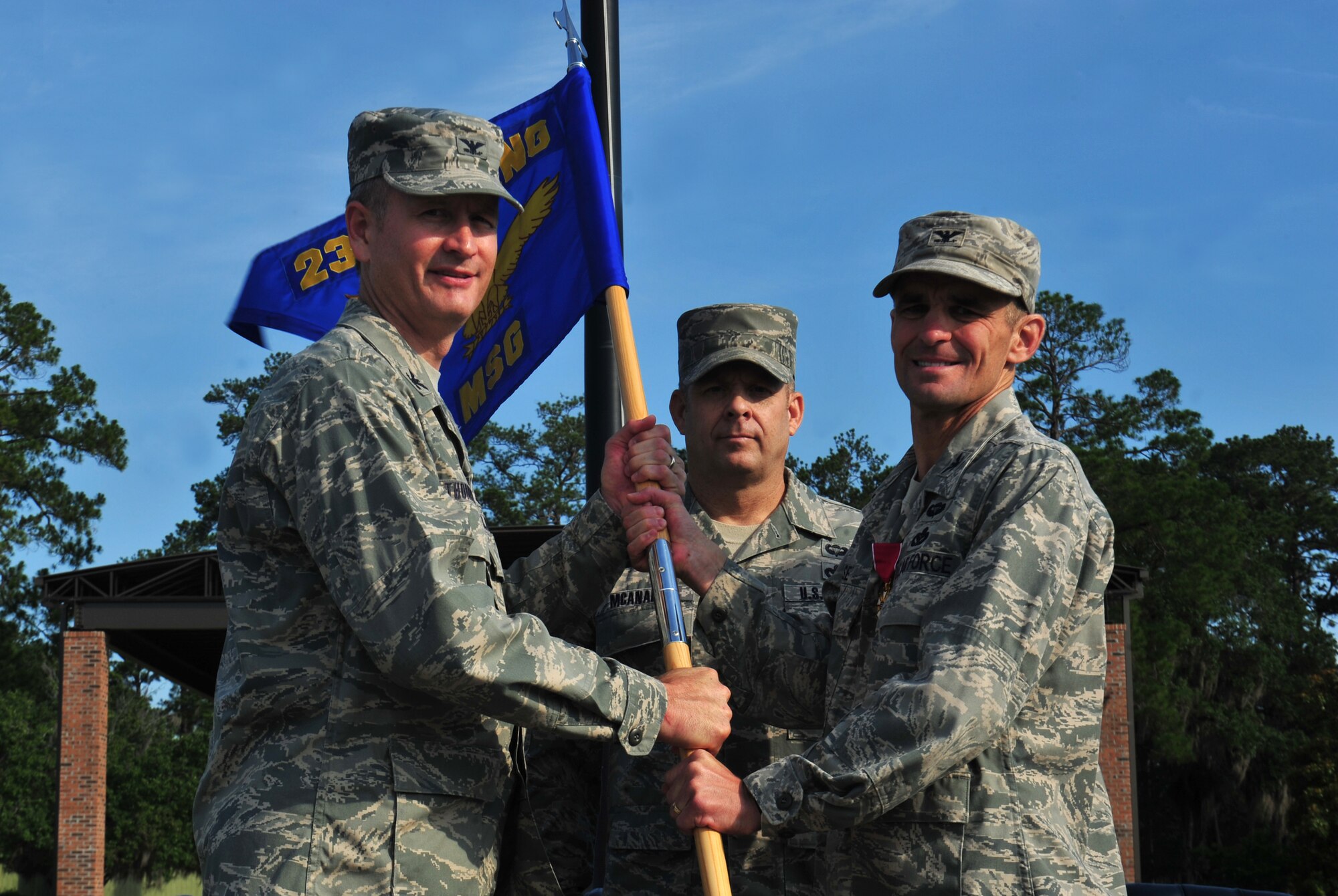 U.S. Air Force Col. Mark Ruse, 23d Mission Support Group outgoing commander, relinquishes command by passing the guidon to Col. Billy Thompson, 23d Wing commander, during a change of command ceremony at Moody Air Force Base, Ga., June 15, 2012. Thompson then passed the flag to the incoming Commander Col. Edward Ford. (U.S. Air Force photo by Staff Sgt Stephanie Mancha/Released)
