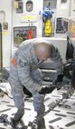 Staff Sgt. Jared Simpach, 86th Aerial Port Squadron, McChord Field, Wash., ties down a vehicle in the cargo area of a C-17 Globemaster using 25,000 pound chains and devices. Experience like this is what Reserve aerial porters will take with them when they deploy to Southwest Asia later this summer.  (U.S. Air Force photo by Tech. Sgt. Michael Paredes)                                                         