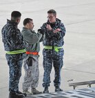 Tech. Sgt. Adam Mantle, 86th Aerial Port Squadron, McChord Field, Wash., (center), demonstrates spotting hand signals to two Sailors during a joint training event here in March 2012. Experience like this is what Reserve aerial porters will take with them when they deploy to Southwest Asia later this summer.  (U.S. Air Force photo by Tech. Sgt. Michael Paredes)                          