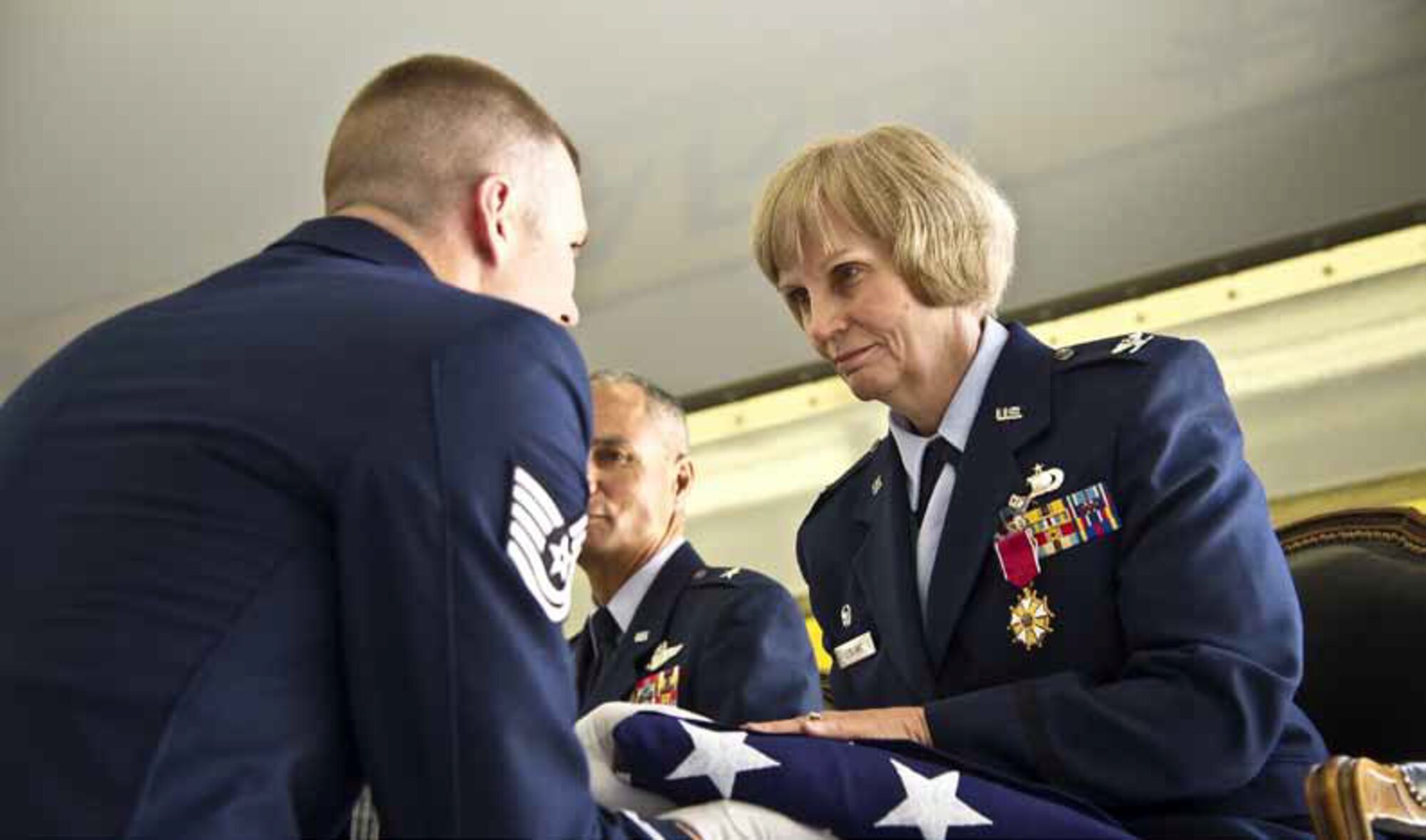 Tech. Sgt. Kyle Platt, Blue Eagles Total Force Honor Guard, presents Col. LeBlanc a folded flag during her retirement ceremony on June 10. (U.S. Air Force photo by Tech. Sgt. Chris Hibben)