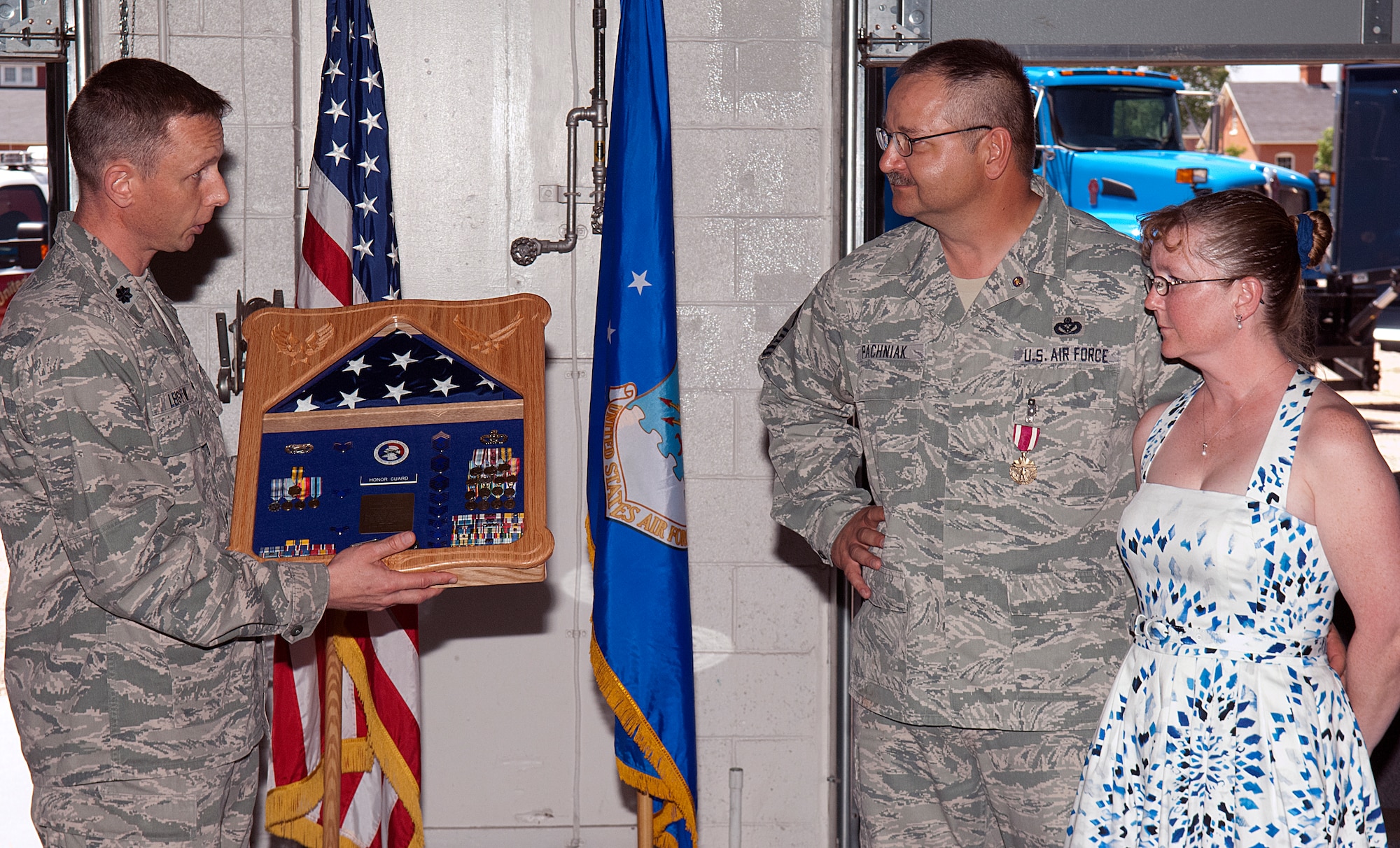 Lt. Col. Travis Leighton, 90th Civil Engineer Squadron commander, presents Chief Master Sgt. Thomas Pachniak, 90th CES, with a shadow box during Pachniak’s retirement ceremony June 8 at F. E. Warren Air Force Base, Wyo. Pachniak is joined by his wife, Angie, who is formerly active duty. The left portion of the shadow box commemorates her time in the Air Force where the Pachniaks met. (U.S. Air Force photo by R.J. Oriez)