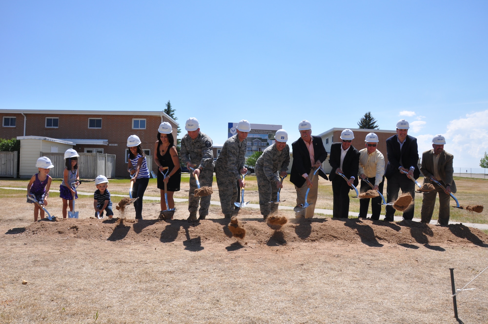 Col. Christopher Coffelt, 90th Missile Wing commander, and Lt. Col. Travis Leighton, 90th Civil Engineer Squadron commander, take part in a ceremonial groundbreaking with Jim Taylor, President of Balfour Beatty Construction; Barrett Larwin, Regional Vice President of Balfour Beatty Communities; Dave Dillow, Vice President of Woolpert; Frank Santoro, Vice President of Balfour Beatty Construction; and Dave Cloutier, Renovations Manager for Balfour Beatty Communities; along with Master Sgt. Justin Witte, 90th Missile Security Forces Squadron; his wife Frances; and their children, Tatiana, Natasha, Natalie and Justin Witte, Jr., June 8 in the Capehart Housing area on base. The groundbreaking ceremony commemorates a new phase in the ongoing project to provide improved housing for Airmen and their families, including the development of a new neighborhood consisting of 98 homes designated for junior enlisted, senior enlisted, and company grade officer families. (U.S. Air Force photo by Senior Airman Dan Gage)