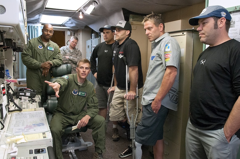 1st. Lt. Edward Warren, 321st Missile Squadron, explains the console of a launch control center to Paul Thomas, Mike Schultz, Jim Wazny and Chris Ridgeway, members of the Baja 1000, a group of amputee athletes taking part in a resiliency tour conducted by Amercian300 Warrior Tours and presented by Air Force Global Strike Command. Schultz, Wazny and Ridgeway plan on competing in the Baja 1000, an off-road race the length of the Baja California Peninsula, as part of a motorcycle team coached by Thomas. (U.S. Air Force photo by R.J. Oriez)