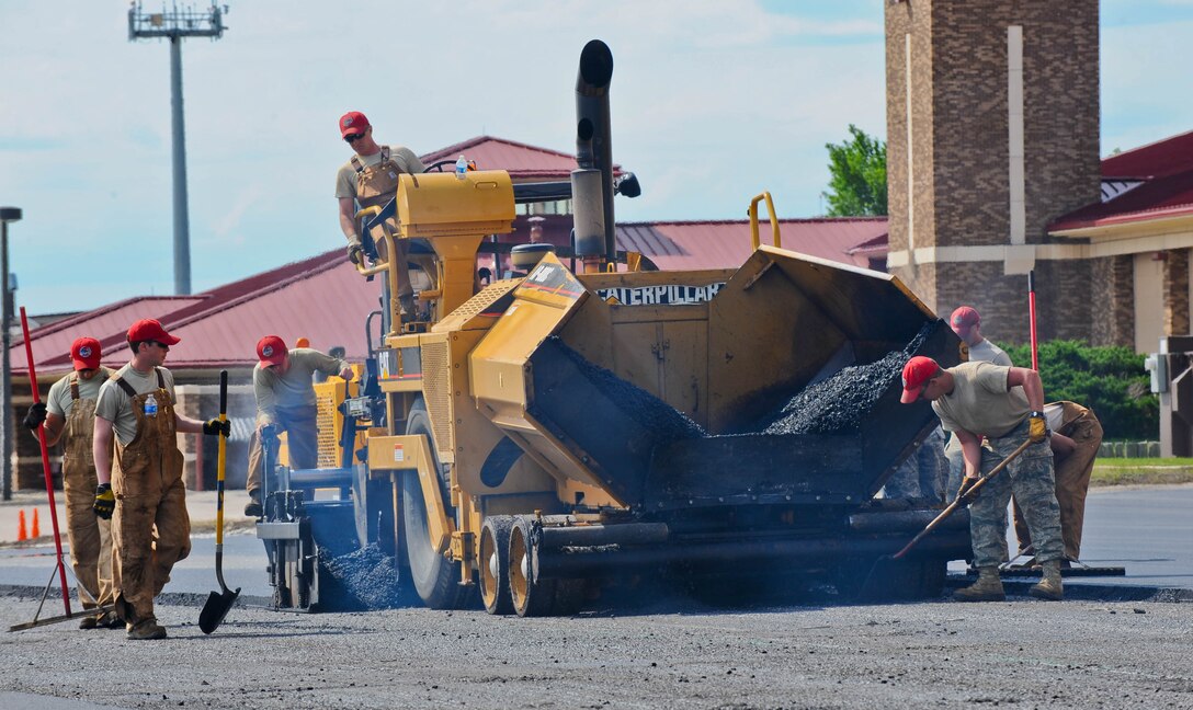 Airmen assigned to the 819th RED HORSE Squadron from Malmstrom Air Force Base, Mont., pave the Pride Hangar parking lot at Ellsworth Air Force Base, S.D., June 12, 2012. RED HORSE equipment engineers used 42,000 tons of asphalt to complete the project. The Air Force saved approximately $300,000 by using the RED HORSE team instead of a civilian contractor. (U.S. Air Force photo by Airman 1st Class Zachary Hada/Released)