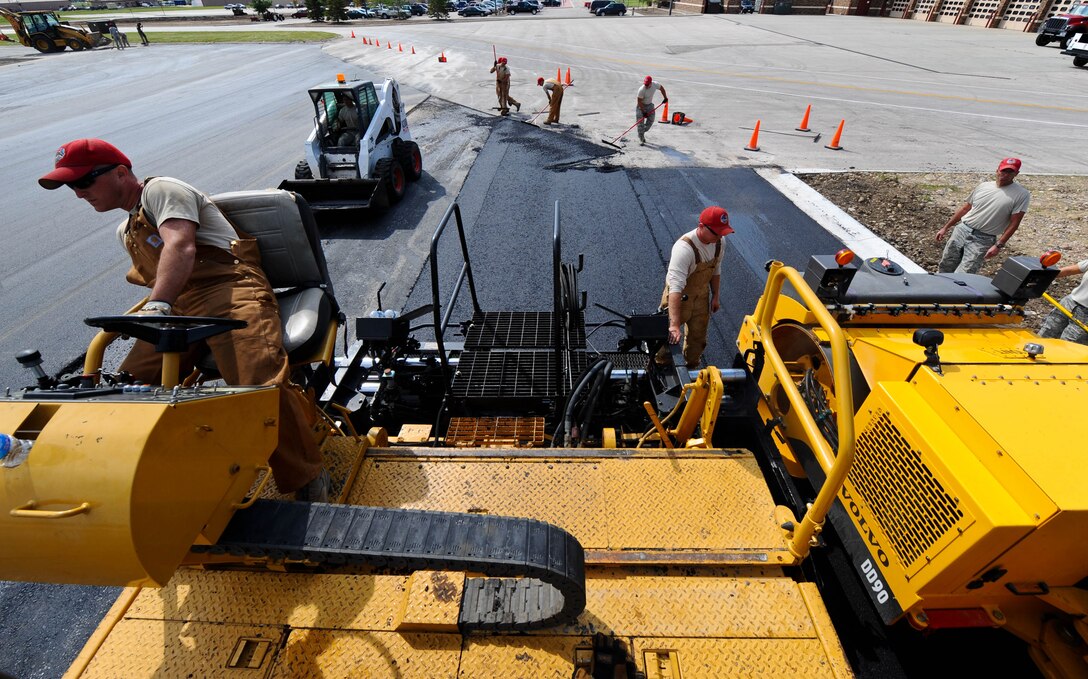 Airmen from the 819th RED HORSE Squadron from Malmstrom Air Force Base, Mont., pave the Pride Hangar parking lot at Ellsworth Air Force Base, S.D., June 12, 2012. RED HORSE Airmen are specialized engineers uniquely situated to deploy anywhere in the world and conduct base build-up operations under extreme conditions. (U.S. Air Force photo by Airman 1st Class Zachary Hada/Released)