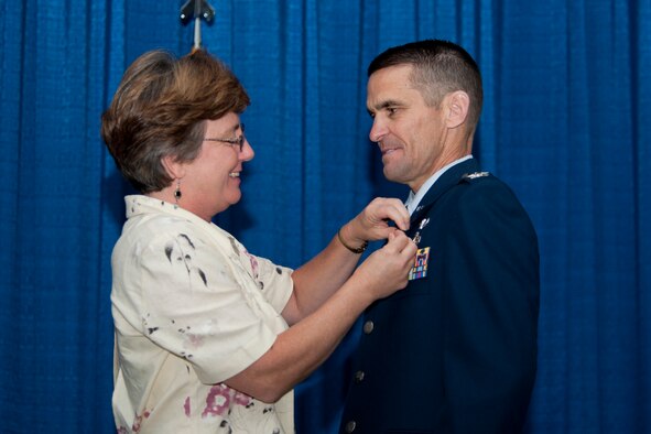 U.S. Air Force Col. Mark Ruse, former 23d Mission Support Group commander, receives his retirement pin from his wife, Lisa, during a retirement ceremony June 15, 2012, at Moody Air Force Base, Ga. Ruse started his Air Force career at Moody with the 347th Civil Engineer Squadron in 1988 and assumed command of the 23d MSG in December 2009. (U.S. Air Force photo by Staff Sgt. Jamal D. Sutter/Released)