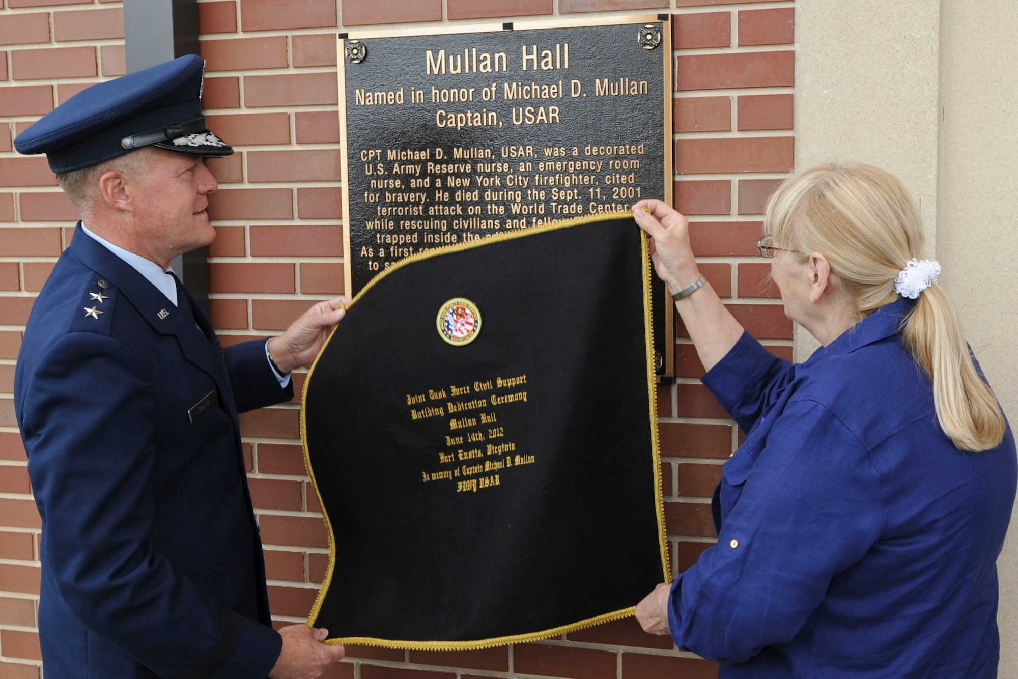 U.S. Air Force Maj. Gen. Jonathan T. Treacy, Joint Task Force-Civil Support commander, and Theresa Mullan, ceremonially unveil the memorial plaque dedicating the JTF-CS headquarters as “Mullen Hall,” in a ceremony at Ft. Eustis, Va., June 14, 2012. The building is named in honor of Theresa's son, the late U.S. Army Capt. Michael D. Mullan, a reservist, emergency-room nurse and decorated New York City firefighter who died while attempting to rescue fellow firefighters from the Marriott Hotel adjacent to the World Trade Center towers during the terrorist attacks of Sept. 11, 2001. (U.S. Air Force photo by Senior Airman Wesley Farnsworth/Released)