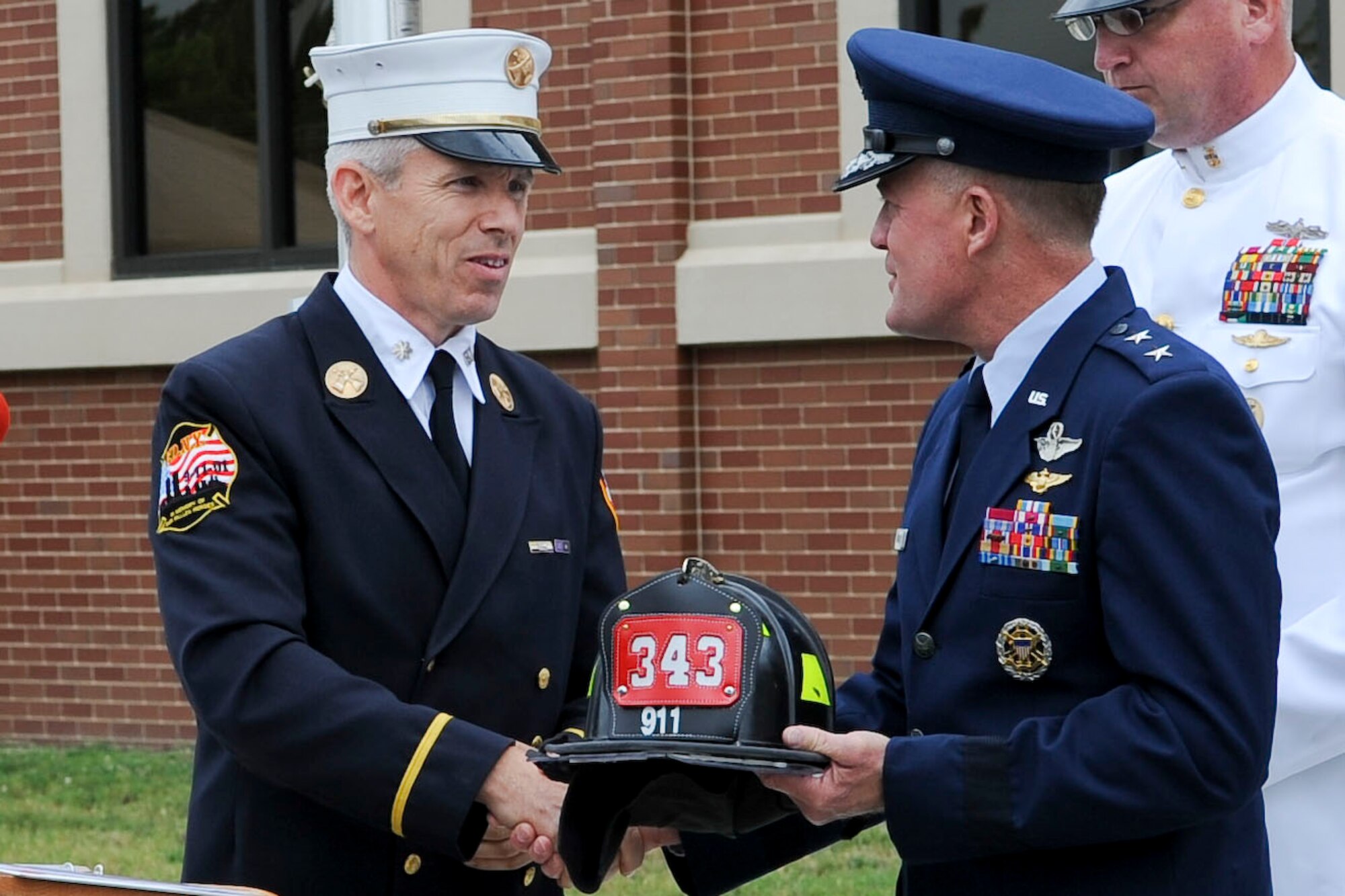 Thomas McCarthy, Fire Department of New York battalion chief, presents U.S. Air Force Maj. Gen. Jonathan T. Treacy, Joint Task Force Civil Support commander, a memorial fire helmet in appreciation of honoring the late U.S. Army Capt. Michael D. Mullan during the Joint Task Force-Civil Support headquarters building dedication ceremony at Ft. Eustis, Va., June 14, 2012. The building was named in honor of Mullan, a reservist, emergency room nurse and decorated New York City firefighter who died while attempting to rescue fellow firefighters from the Marriott Hotel adjacent to the World Trade Center towers during the terrorist attacks of Sept. 11, 2001. (U.S. Air Force photo by Senior Airman Wesley Farnsworth/Released)