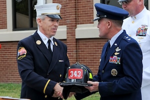 Thomas McCarthy, Fire Department of New York battalion chief, presents U.S. Air Force Maj. Gen. Jonathan T. Treacy, Joint Task Force Civil Support commander, a memorial fire helmet in appreciation of honoring the late U.S. Army Capt. Michael D. Mullan during the Joint Task Force-Civil Support headquarters building dedication ceremony at Ft. Eustis, Va., June 14, 2012. The building was named in honor of Mullan, a reservist, emergency room nurse and decorated New York City firefighter who died while attempting to rescue fellow firefighters from the Marriott Hotel adjacent to the World Trade Center towers during the terrorist attacks of Sept. 11, 2001. (U.S. Air Force photo by Senior Airman Wesley Farnsworth/Released)