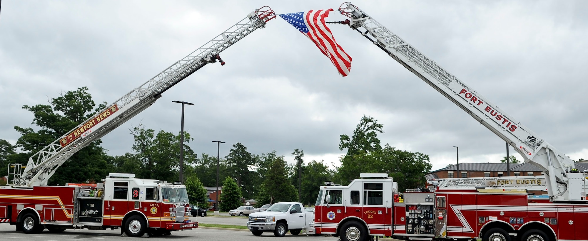 Ladder engines from the Newport News and Fort Eustis fire departments fly the U.S. Flag during the Joint Task Force-Civil Support headquarters building dedication ceremony at Ft. Eustis, Va., June 14, 2012. The building was renamed in honor of the late U.S. Army Capt. Michael D. Mullan, a reservist, emergency room nurse and decorated New York City firefighter who died while attempting to rescue fellow firefighters from the Marriott Hotel adjacent to the World Trade Center towers during the terrorist attacks of Sept. 11, 2001. (U.S. Air Force photo by Senior Airman Wesley Farnsworth/Released)