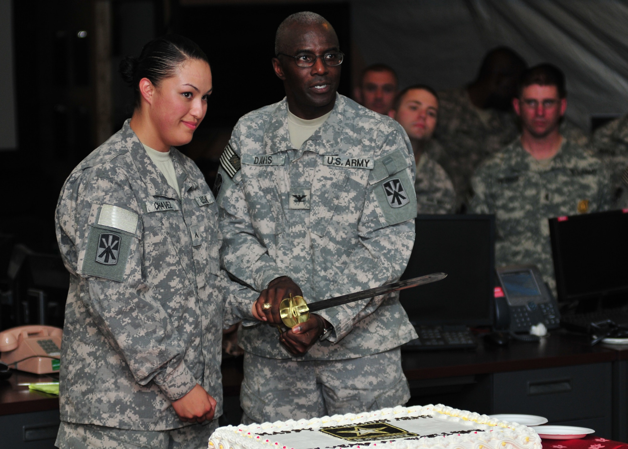 Private Gennesis C. Chavez, a supply specialist with the 11th Air Defense Artillery "Imperial" Brigade, and Col. Reginald Davis, 11th ADA BDE commander, prepare to cut the Army birthday cake at a formal ceremony held in the brigade’s forward deployed tactical operation center June 14, in celebration of the Army's 237th birthday. (U.S. Army photo/Sgt. Todd Robinson)