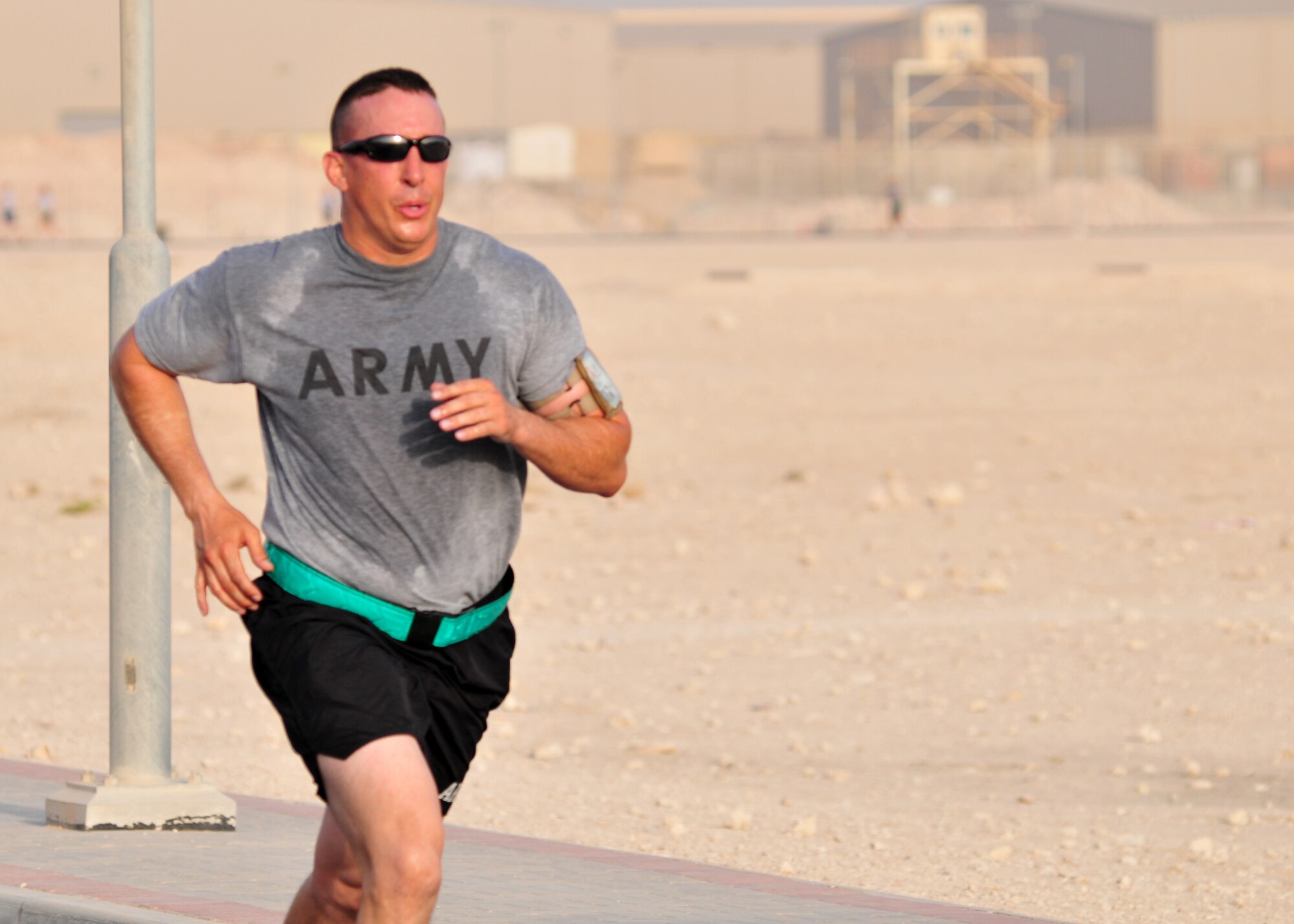 Corpral David A. Tyrpin, Headguarters and Headquarters battery, 11th Air Defense Artillery Brigade radar repair technician, runs the 237th Army Birthday 5K run near the base gymnasium June 14 while deployed to Southwest Asia supporting Operation Enduring Freedom. (U.S. Army photo/Sgt. Todd W. Robinson)