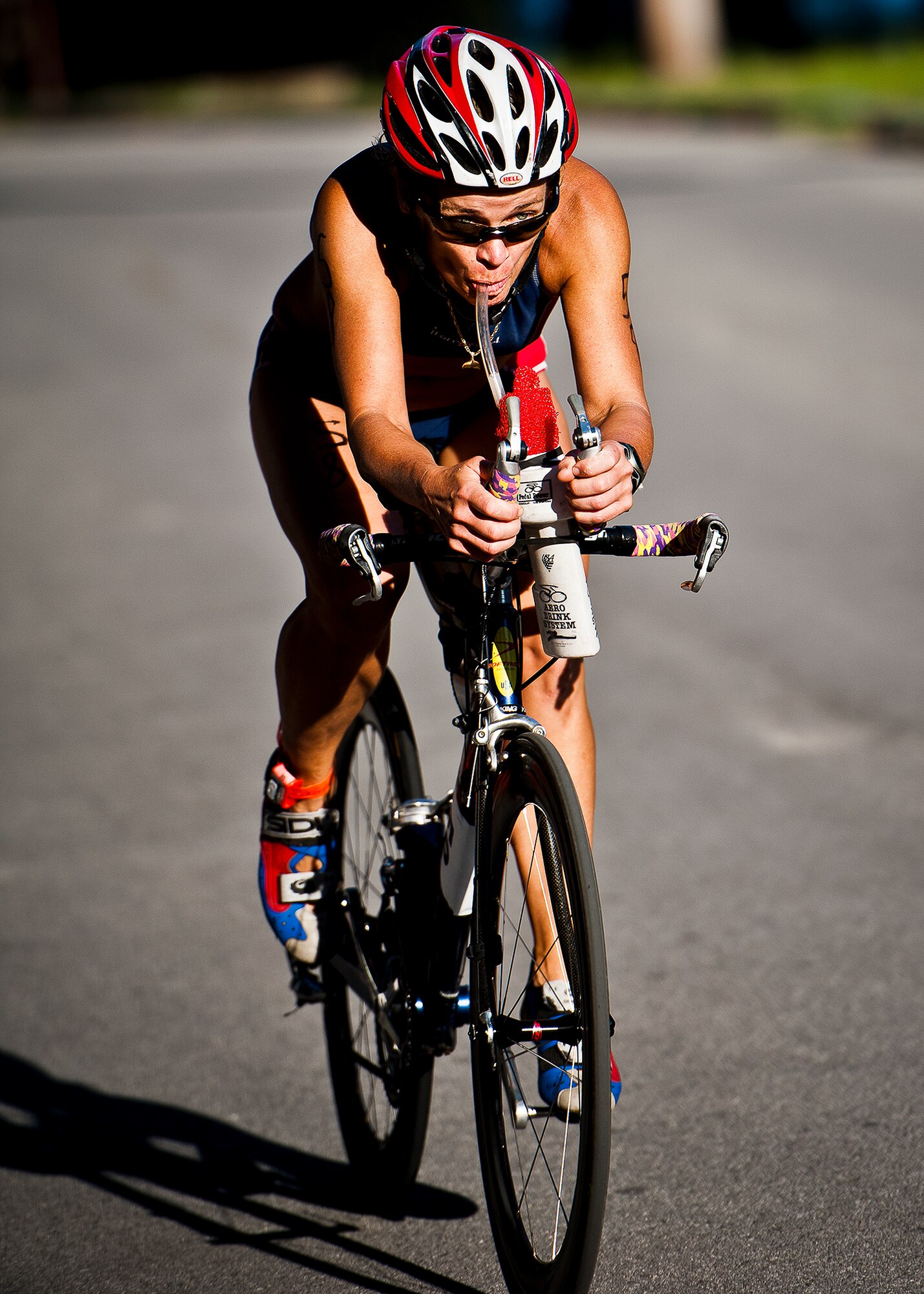 Mara Costabile hydrates while pedaling for the finish of the eight and a half-mile bike ride section of the My-First-Tri competition June 16 at Eglin Air Force Base, Fla.  More than 140 people competed in the 13th annual base triathlon.  (U.S. Air Force photo/Samuel King Jr.)