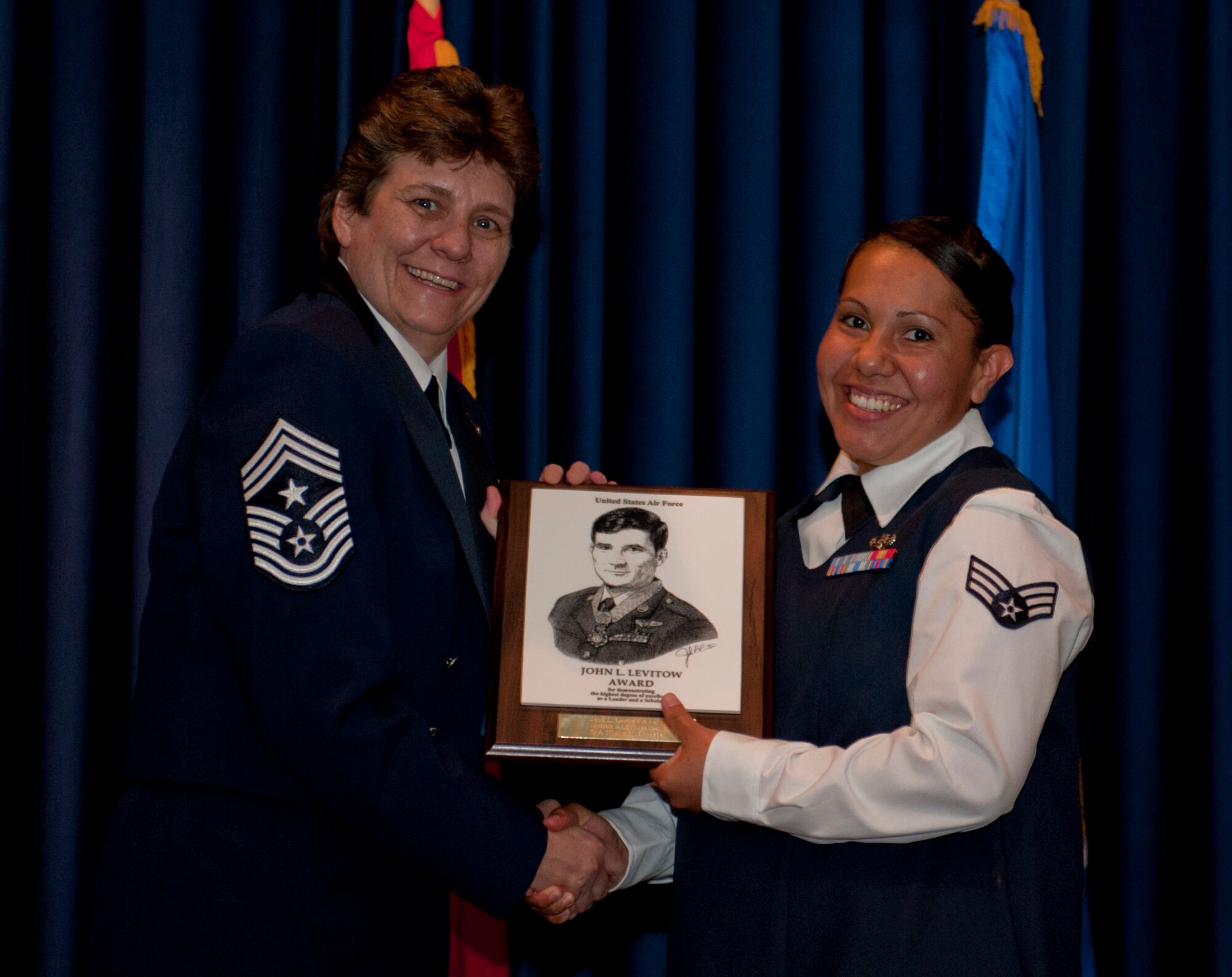 Senior Airman Nisha Morris, 39th Communications Squadron, receives the John L. Levitow Award from Chief Master Sgt. Nancy Judge, 39th Air Base Wing command chief, during the Class 12-E Incirlik Airman Leadership School graduation June 14, 2012, at Incirlik Air Base, Turkey. The Levitow Award is the highest achievement for enlisted Airmen enrolled in U.S. Air Force professional military education. There are four levels of PME: ALS, NCO academy, Air Force Senior NCO Academy and the Chief Master Sergeant Leadership Course. (U.S. Air Force photo by Senior Airman Anthony Sanchelli/Released)