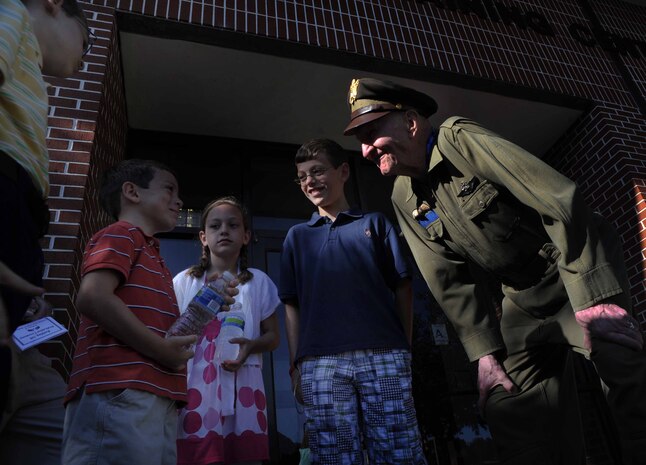 Retired Col. Gail Halvorsen, the famed "Candy Bomber", speaks with children moments after the C-17 Aircrew Training Center was dedicated in honor of him, as one of the finest mobility legends. Halvorsen was a command pilot in the United States Air Force. He is best known for piloting C-47s and C-54s during the Berlin Airlift from 1948-1949. Halvorsen dropped candy attached to parachutes to children below. His main goal was to raise the morale of the children during the time of uncertainty. (U.S. Air Force photo/Airman 1st Class Ashlee Galloway)
