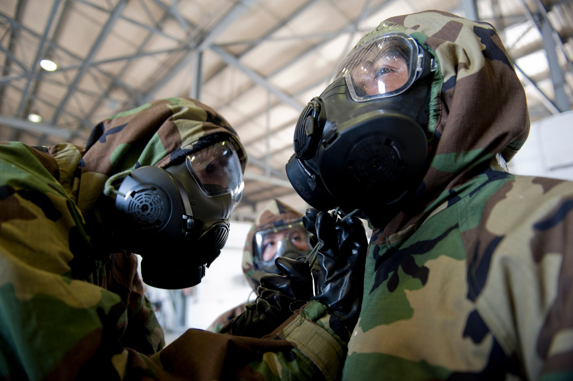 Airmen perform buddy checks to ensure their mission-oriented protective posture gear fits properly during a Phase II Operational Readiness Exercise June 13, 2012, at Incirlik Air Base, Turkey. The MOPP gear is designed to protect from nuclear, biological, chemical and conventional attacks. (U.S. Air Force photo by Senior Airman Anthony Sanchelli/Released)
