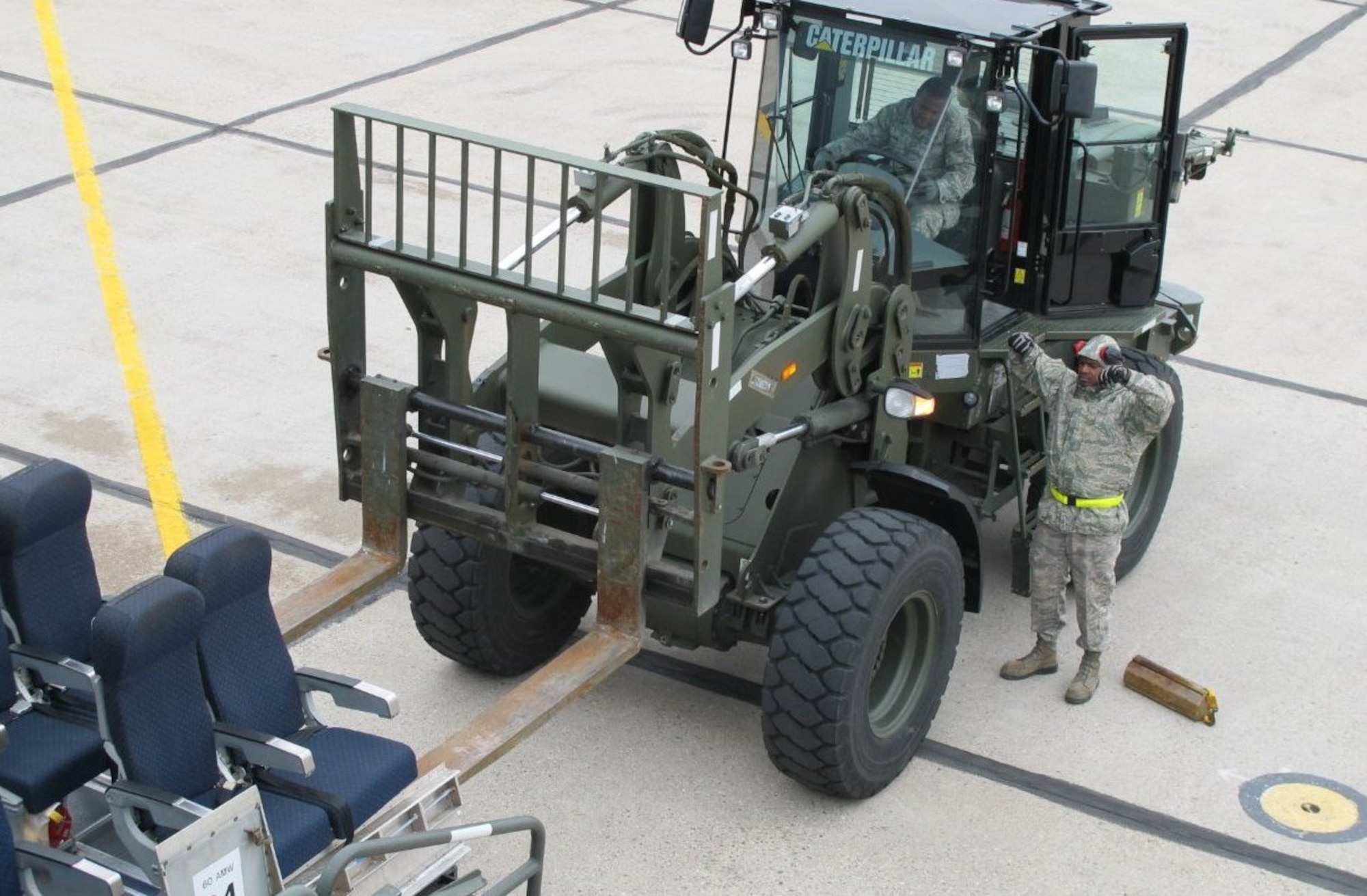 Senior Airman Edward Johnson and Senior Airman Kevan Graham (in vehicle) of the 46th Aerial Port Squadron, Dover Air Force Base, Del., load seats onto an aircraft  June 1, 2012, during the Maple Flag international air combat exercise in Cold Lake, Alberta, Canada. (Courtesy photo)