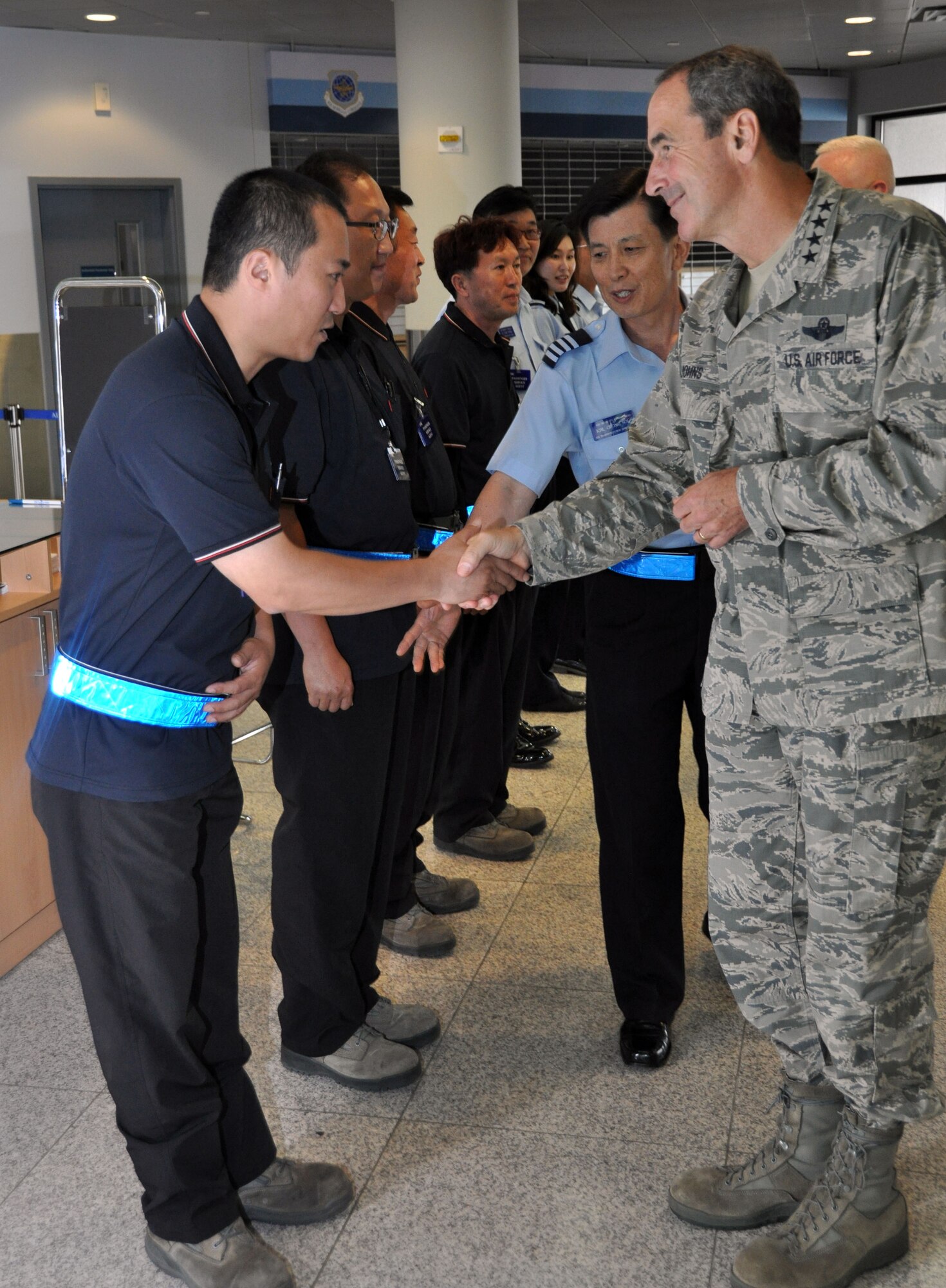 Korean contractors from the 731st Air Mobility Squadron passenger terminal greet Gen. Raymond Johns Jr., Air Mobility Command commander, during his visit to Osan Air base, Republic of Korea, June 13, 2012. Johns’ visited Osan to observe the capabilities and processes of the passenger terminal.  U.S. Air Force photo/Senior Airman Michael Battles)