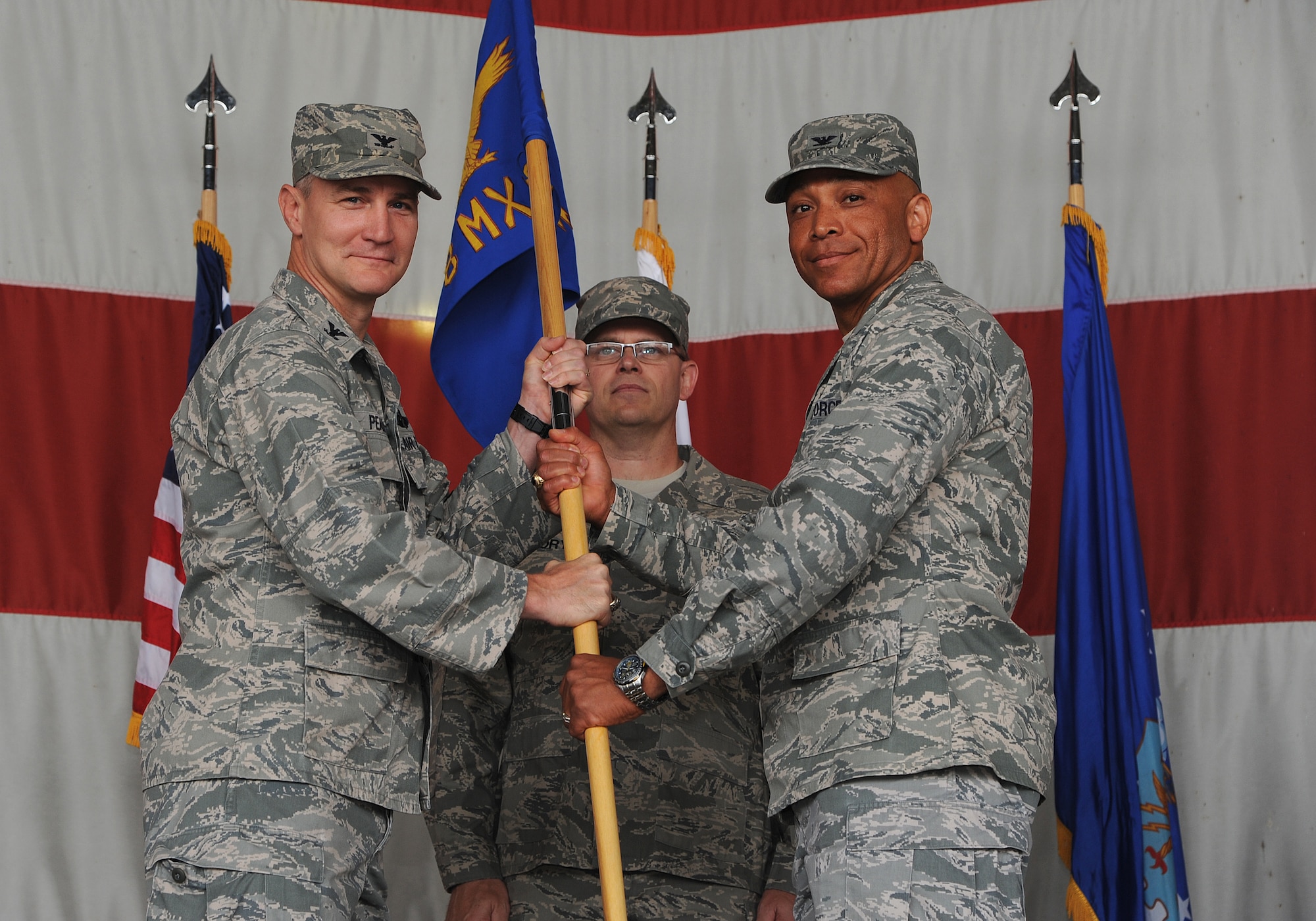 Col. John Pearse, 8th Fighter Wing commander, hands the 8th Maintenance Group guidon to Col. Ray Lindsay, 8th MXG commander, during a change of command ceremony at Kunsan Air Base, Republic of Korea, June 15, 2012. (U.S. Air Force photo/Staff Sgt. Rasheen A. Douglas)