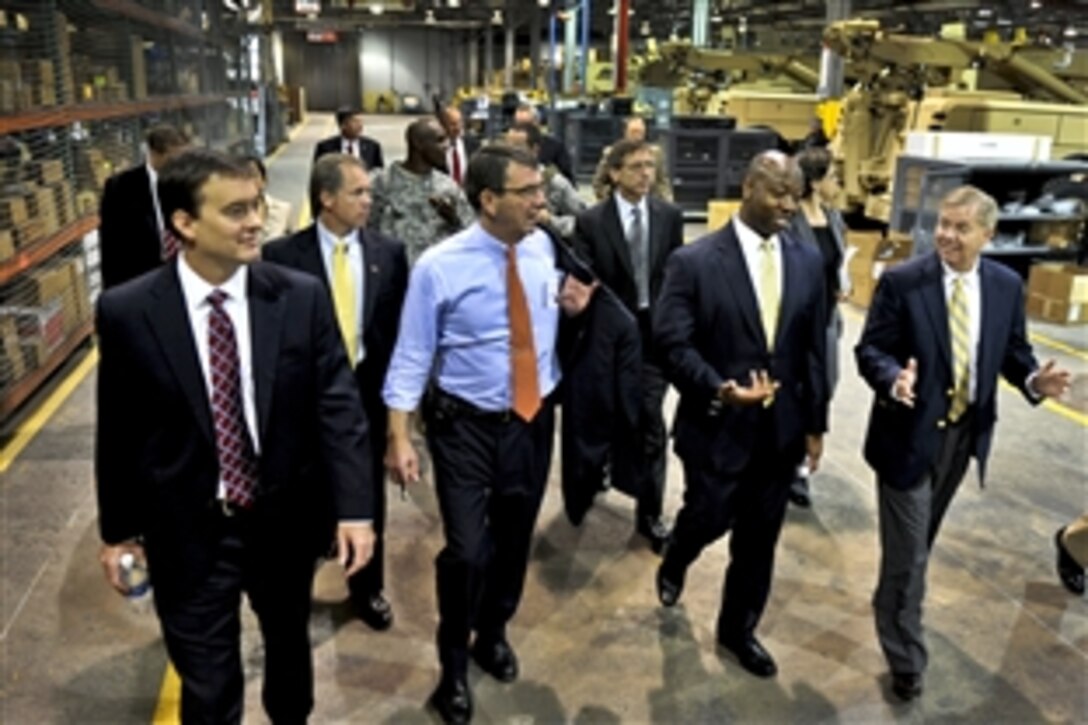 Deputy Defense Secretary Ashton B. Carter, second from left, receives a tour of the Vehicular Integrated Solutions facility as he visits Joint Base Charleston in Charleston, S.C., June 18, 2012. U.S. Rep. Tim Scott, second from right, U.S. Sen. Lindsey Graham, far right, both of South Carolina, and Christopher A. Miller, far left, executive director of Space and Naval Warfare Systems Center Atlantic, joined Carter.