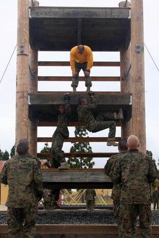 A drill instructor of Company F, 2nd Recruit Training Battalion, supervises recruits as they use different techniques to climb up a tower June 4 aboard Marine Corps Recruit Depot San Diego.The Confidence Course is one of the many challenges that recruits must overcome. The purpose is to negotiate low and high obstacles through technique and by building upper-body strength, endurance and confidence. 