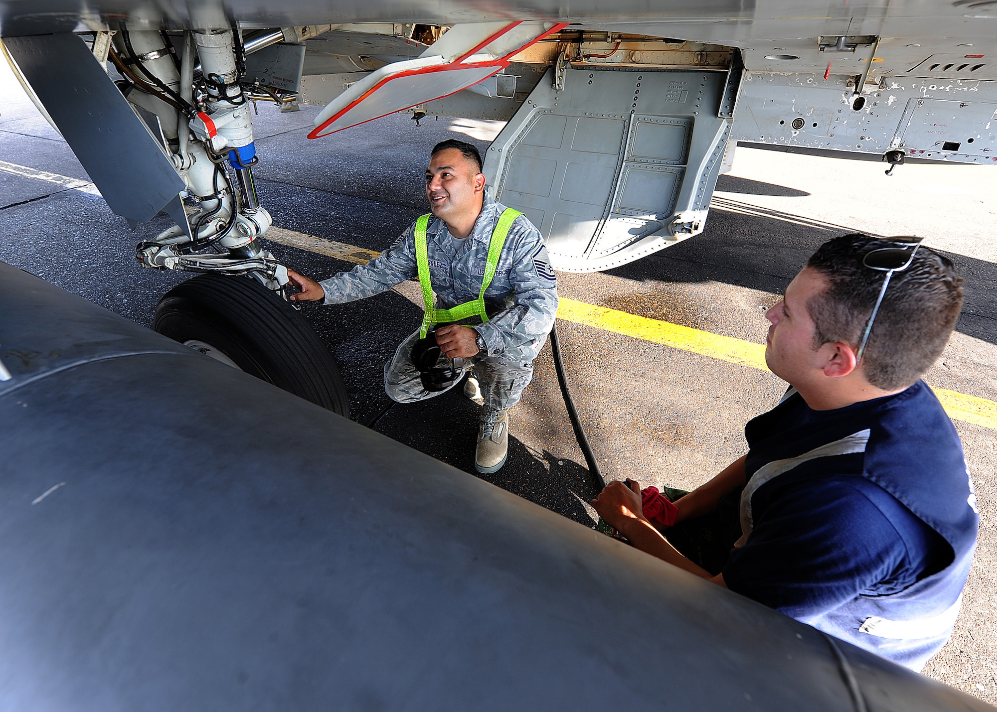 Master Sgt. Roberto Vasquez, 12th AF (AFSOUTH) heavy aircraft manager, and a Colombian crew chief inspect the wheels on a KFIR aircraft prior to take-off June 15, at Comando Aéreo de Combate No. 1 base, Palanquero, Colombia, as part of a month-long Air Mobility Command Building Partner Capacity mission. (U.S. Air Force photo by Tech. Sgt. Lesley Waters)