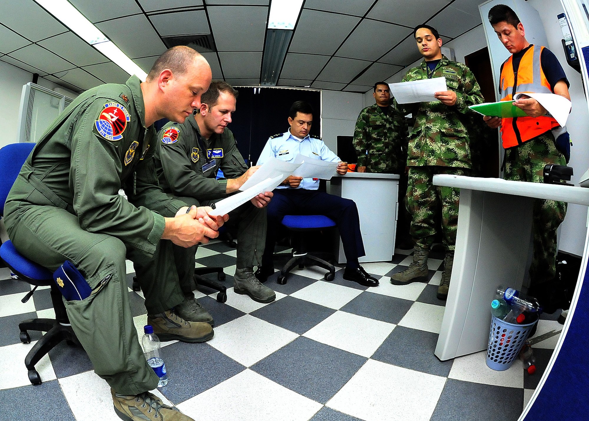 The production superintendent and a maintenance operations center member go over the evening's flight schedule with senior leadership during the MOC briefing June 15, at Comando Aéreo de Combate No. 1 base, Palanquero, Colombia, as part of a month-long Air Mobility Command Building Partner Capacity mission. (U.S. Air Force photo by Tech. Sgt. Lesley Waters)