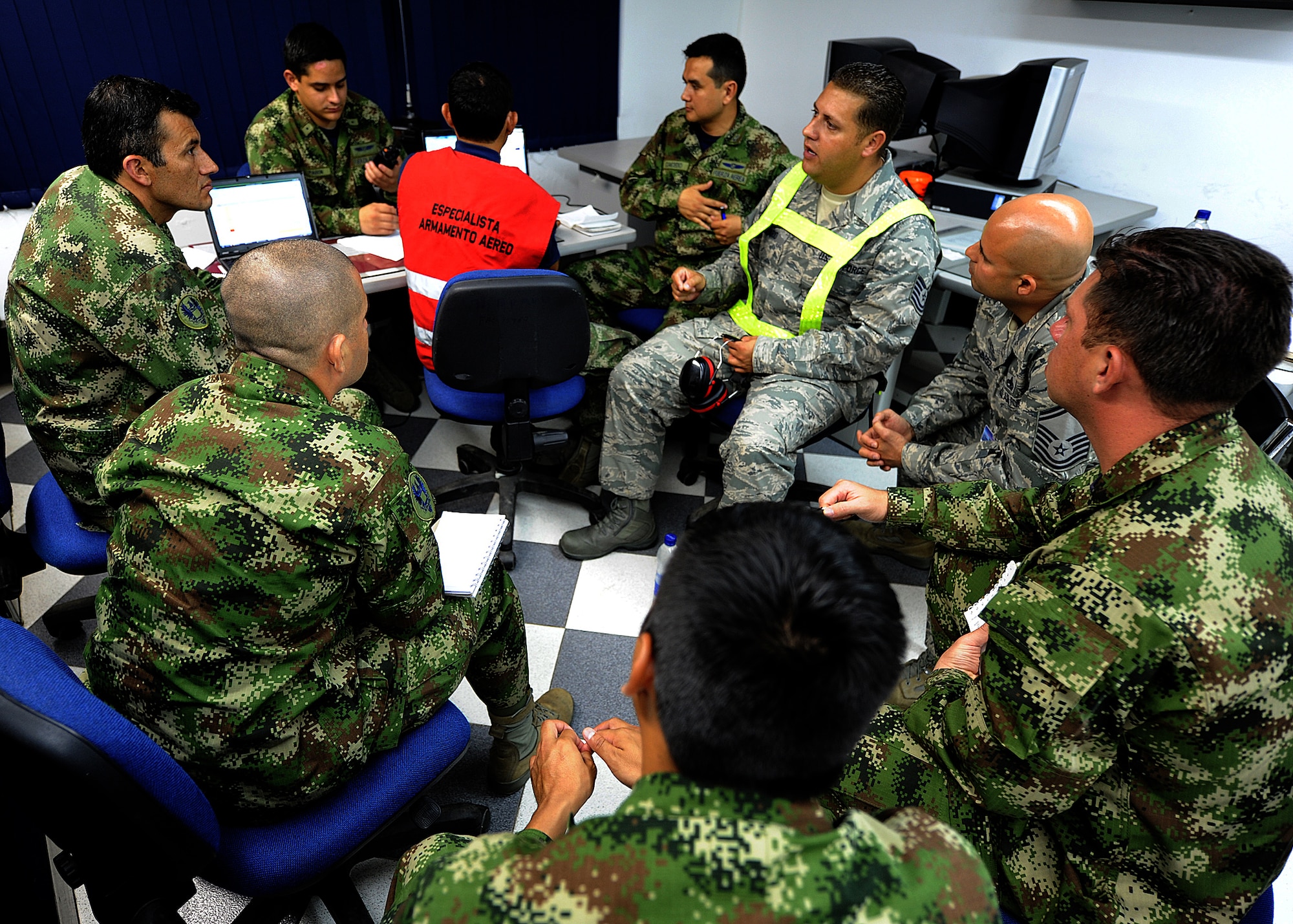 Technical Sgt. Melvin Rosario, Inter-American Air Forces Academy instructor, discusses maintenance operations center procedures to members of the Colombian air force June 13, at Comando Aéreo de Combate No. 1 base, Palanquero, Colombia, as part of a month-long Air Mobility Command Building Partner Capacity mission. (U.S. Air Force photo by Tech. Sgt. Lesley Waters)