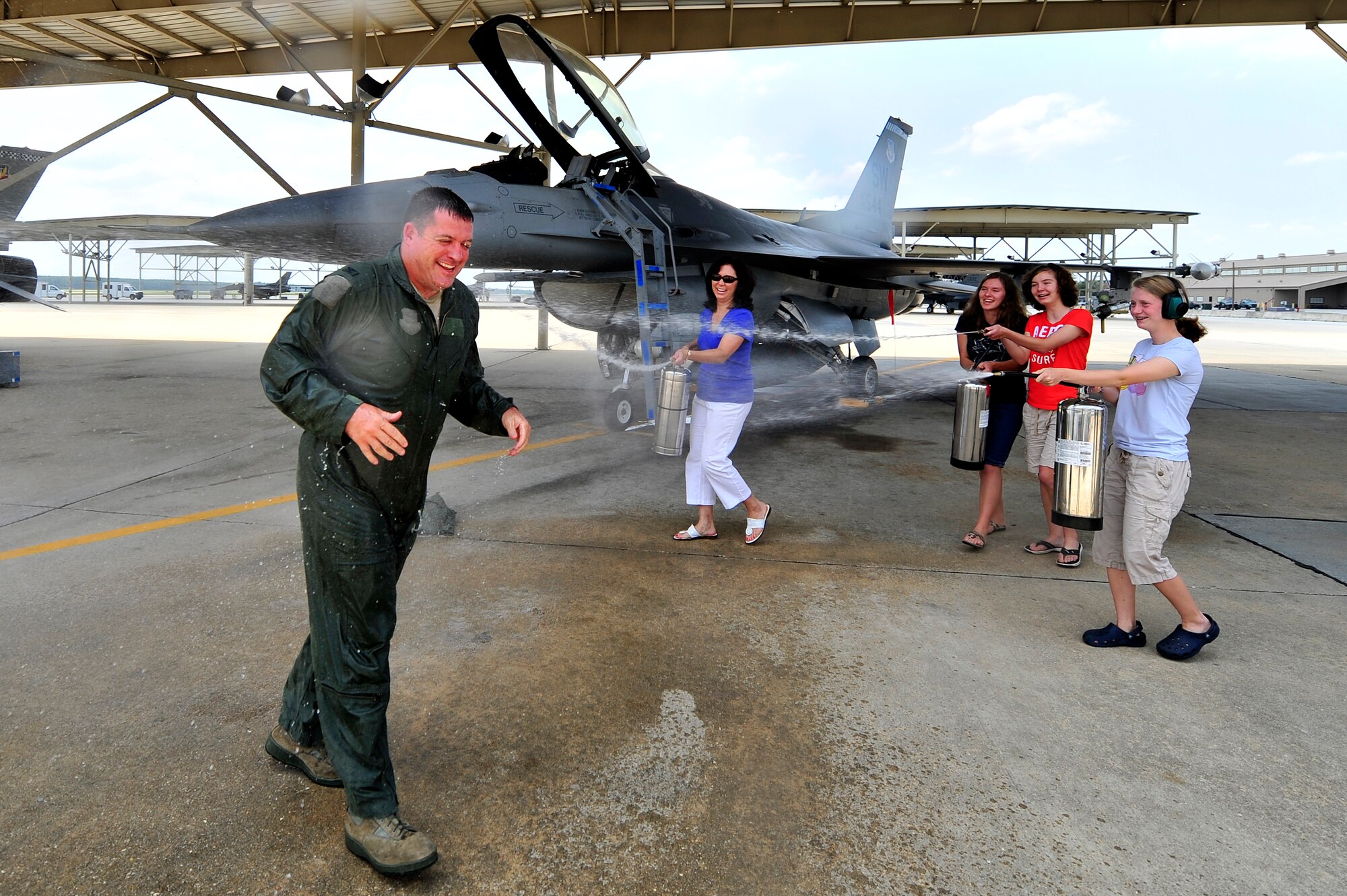 U.S. Air Force Col. Don Godier, 20th Fighter Wing vice commander, is sprayed down by his wife and kids after his final flight, June 19, 2012, Shaw Air Force Base, S.C. The flight was Godier’s last with the 20th FW before moving on to his next assignment at Osan Air Base, South Korea. (U.S. Air Force photo by Senior Airman Kenny Holston)