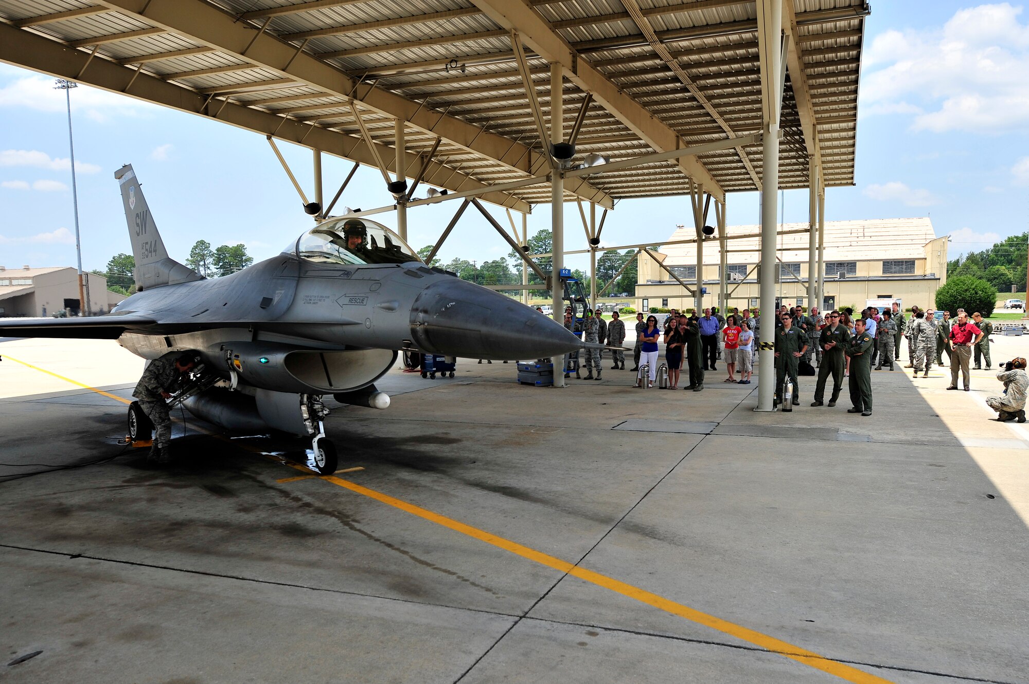 Friends, family and co-workers wait for U.S. Air Force Col. Don Godier, 20th Fighter Wing vice commander, to exit his F-16 Fighting Falcon after his final flight, June 19, 2012, Shaw Air Force Base, S.C. The flight was Godier’s last with the 20th FW before moving on to his next assignment at Osan Air Base, South Korea. (U.S. Air Force photo by Senior Airman Kenny Holston)
