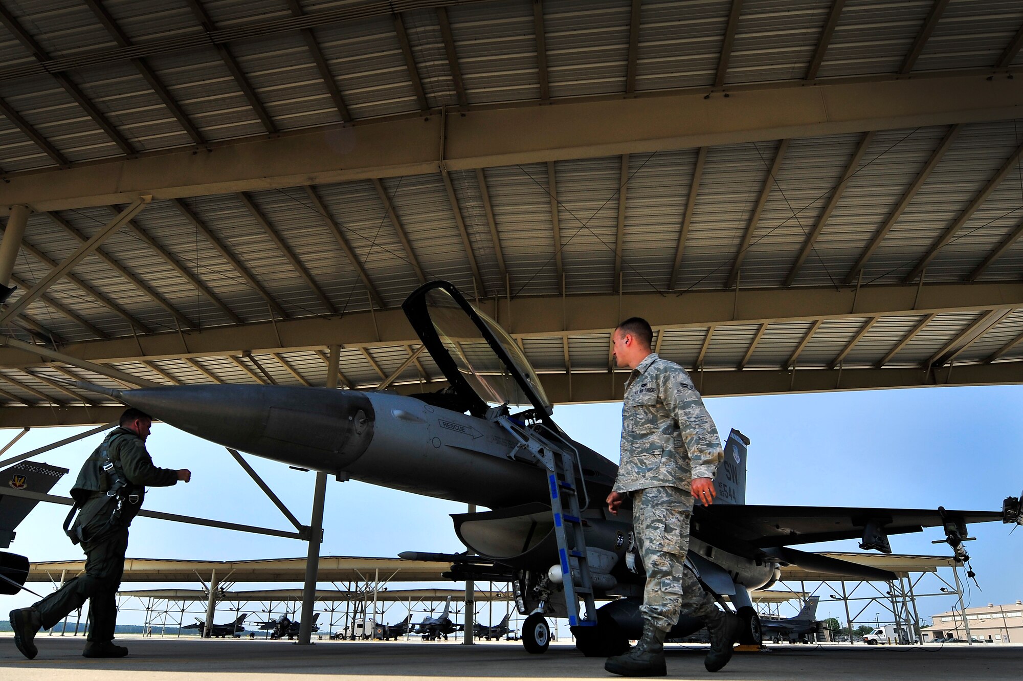 U.S. Air Force Col. Don Godier, 20th Fighter Wing vice commander, (left) and Airman 1st Class Brian Fisher, 20th Aircraft Maintenance Squadron crew chief, go through standard preflight checks before Godier’s final flight, June 19, 2012, Shaw Air Force Base, S.C. The flight was Godier’s last with the 20th FW before moving on to his next assignment at Osan Air Base, South Korea. (U.S. Air Force photo by Senior Airman Kenny Holston)