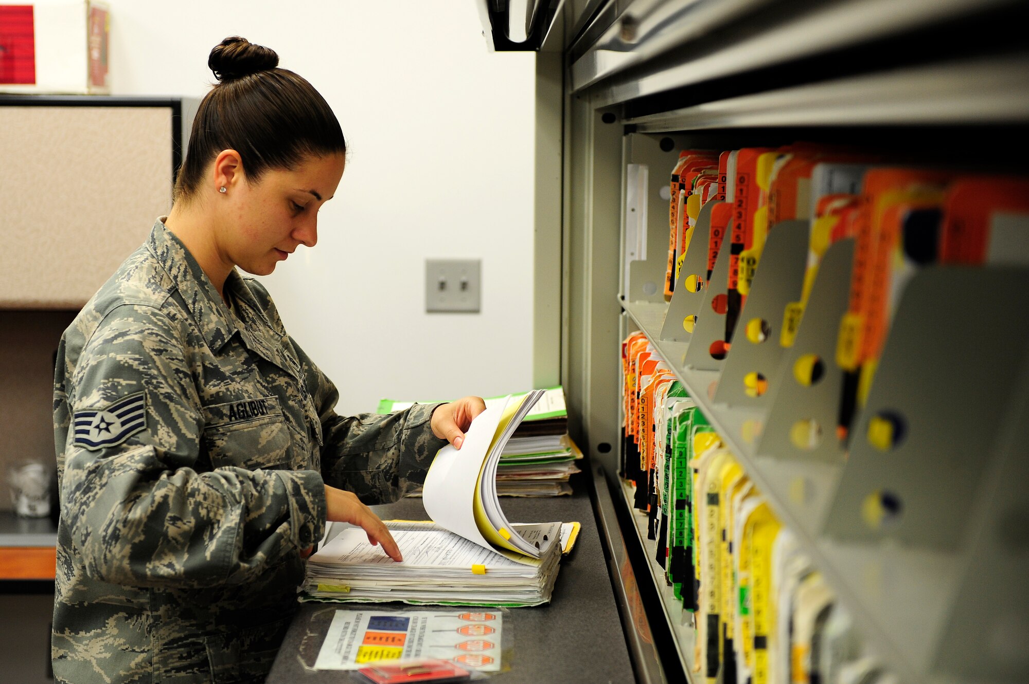 U.S. Air Force Staff Sgt. Jessica Aglibut, 20th Aerospace Medical Squadron medical technician, looks through medical files of patients, which is a typical activity throughout her day at Shaw Air Force Base, S.C., June 18, 2012. Aglibut was selected for the Nurse Enlisted Commissioning Program to become an Air Force officer and nurse. (U.S. Air Force photo by Daniel Blackwell Airman 1st Class/Released)