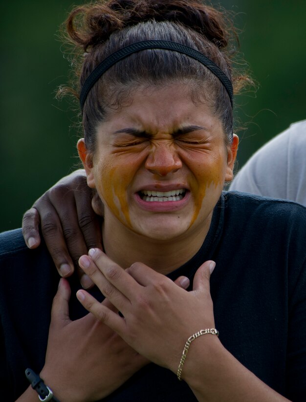 Senior Airman Marixsa Chicas, 11th Security Forces Group member, reacts to being sprayed with Oleoresin Capsicum Spray during familiarization training June 14, 2012, at Joint Base Andrews, Md. Security forces Airman are exposed to OC spray prior to being certified to carry it so they are aware of its affects on whomever they spray, as well as themselves. OC spray is an extremely effective less-than-lethal tool that can be utilized to quell a situation without having to otherwise resort to lethal force.  (U.S. Air Force photo by Senior Airman Perry Aston)(Released))