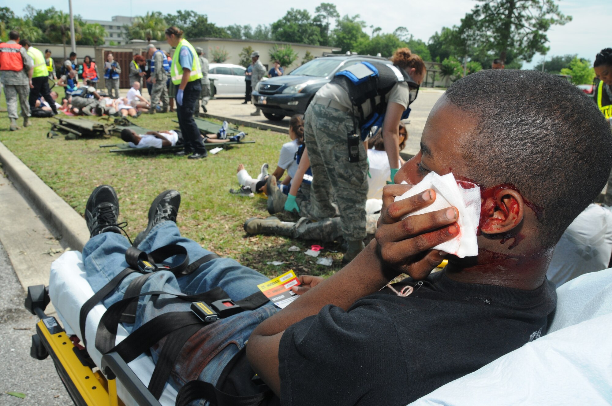 Airman First Class Jontay Ford, 81st Medical Group, portrays a victim with a gunshot wound to the face waiting in the triage area to be loaded into an ambulance for transporting from the Arnold Annex to the Keesler Hospital during Keesler's active shooter exercise, June 12, 2012. The two-day exercise consisted of a lone gunman opening fire with four people killed and 32 injured. The exercise tested the base's ability to respond and recover from a mass casualty event.  (U.S. Air Force photo by Kemberly Groue)
