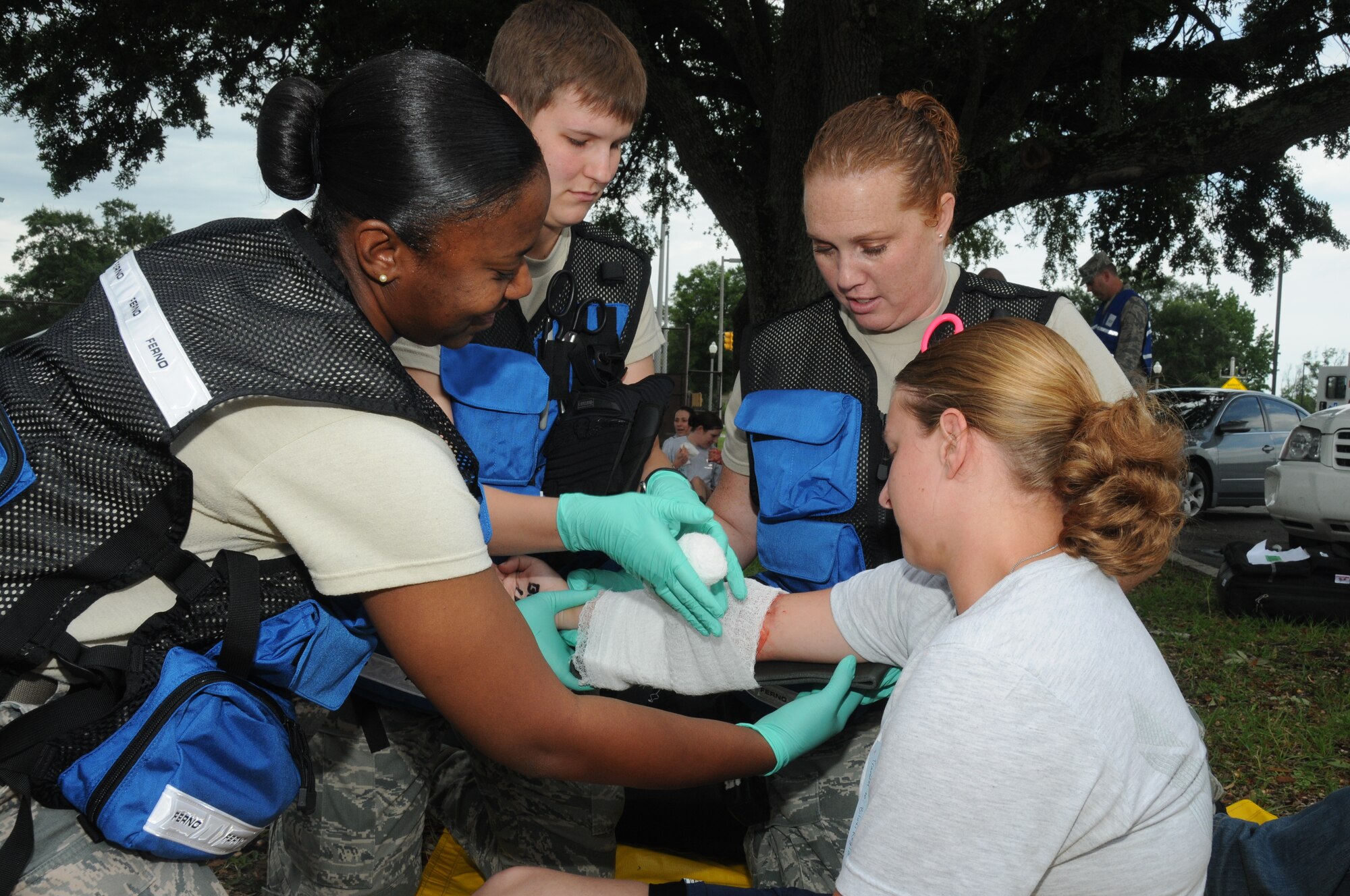 Airmen 1st Class Uylessa Muse and Demi Cook, 81st Medical Support Squadron, receive assistance from Tech. Sgt. Alisha Baxter, 81st Aerospace Medicine Squadron, with administering self-aid and buddy care on Senior Airman Amanda Nesbitt, 81st Contracting Squadron, who portrayed a wounded victim during Keesler's active shooter exercise, June 12, 2012, at the Arnold Annex, Keesler Air Force Base, Miss. The two-day exercise consisted of a lone gunman opening fire with four people killed and 32 injured. The exercise tested the base's ability to respond and recover from a mass casualty event.  (U.S. Air Force photo by Kemberly Groue)