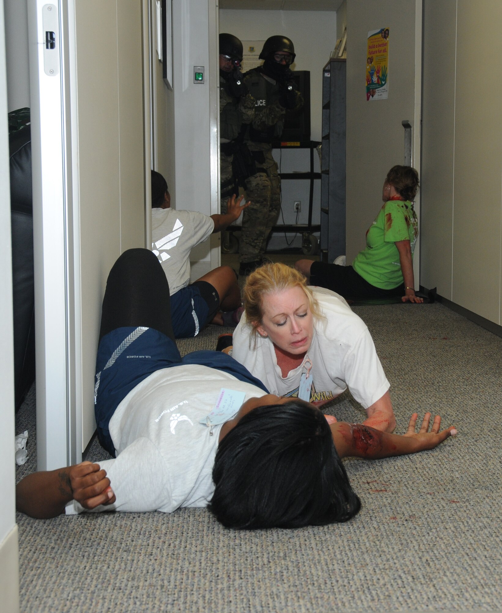 Staff Sgt. Kenya Curtis and Paula Spooner, 81st Medical Operations Squadron, wait for medical assistance as they portray wounded victims during Keesler's active shooter exercise, June 12, 2012, at the Arnold Annex, Keesler Air Force Base, Miss. The two-day exercise consisted of a lone gunman opening fire with four people killed and 32 injured. The exercise tested the base's ability to respond and recover from a mass casualty event.  (U.S. Air Force photo by Kemberly Groue)