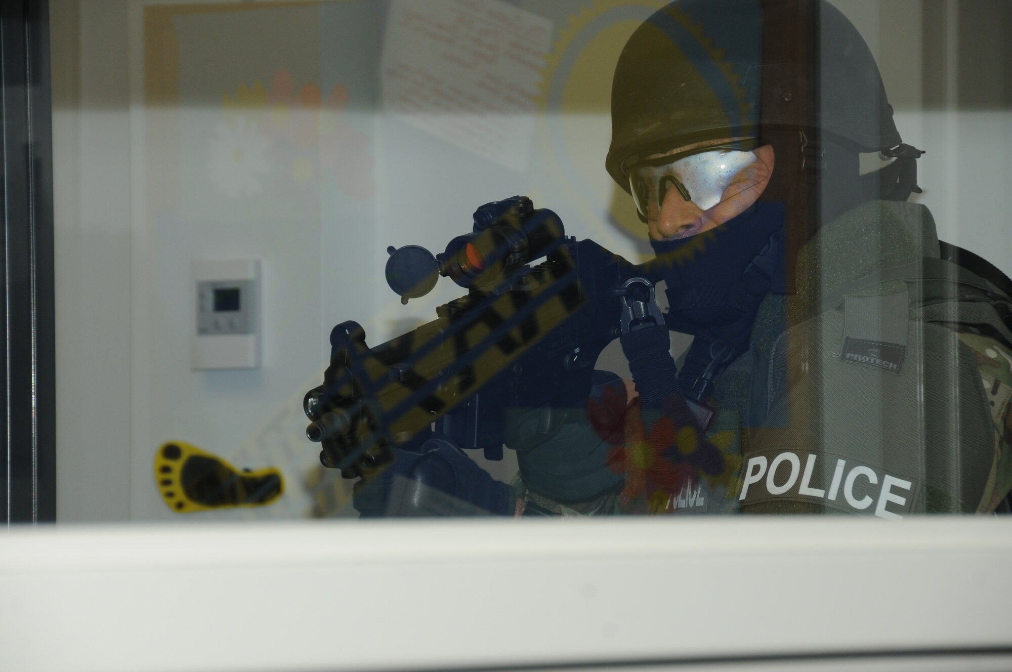 A member of the Biloxi Police Department's Special Response Team (SRT) provides rear security as other team members continue the search for the gunman during Keesler's active shooter exercise, June 12, 2012, at the Arnold Annex, Keesler Air Force Base, Miss. The two-day exercise consisted of a lone gunman opening fire with four people killed and 32 injured. The exercise tested the base's ability to respond and recover from a mass casualty event.  (U.S. Air Force photo by Kemberly Groue)