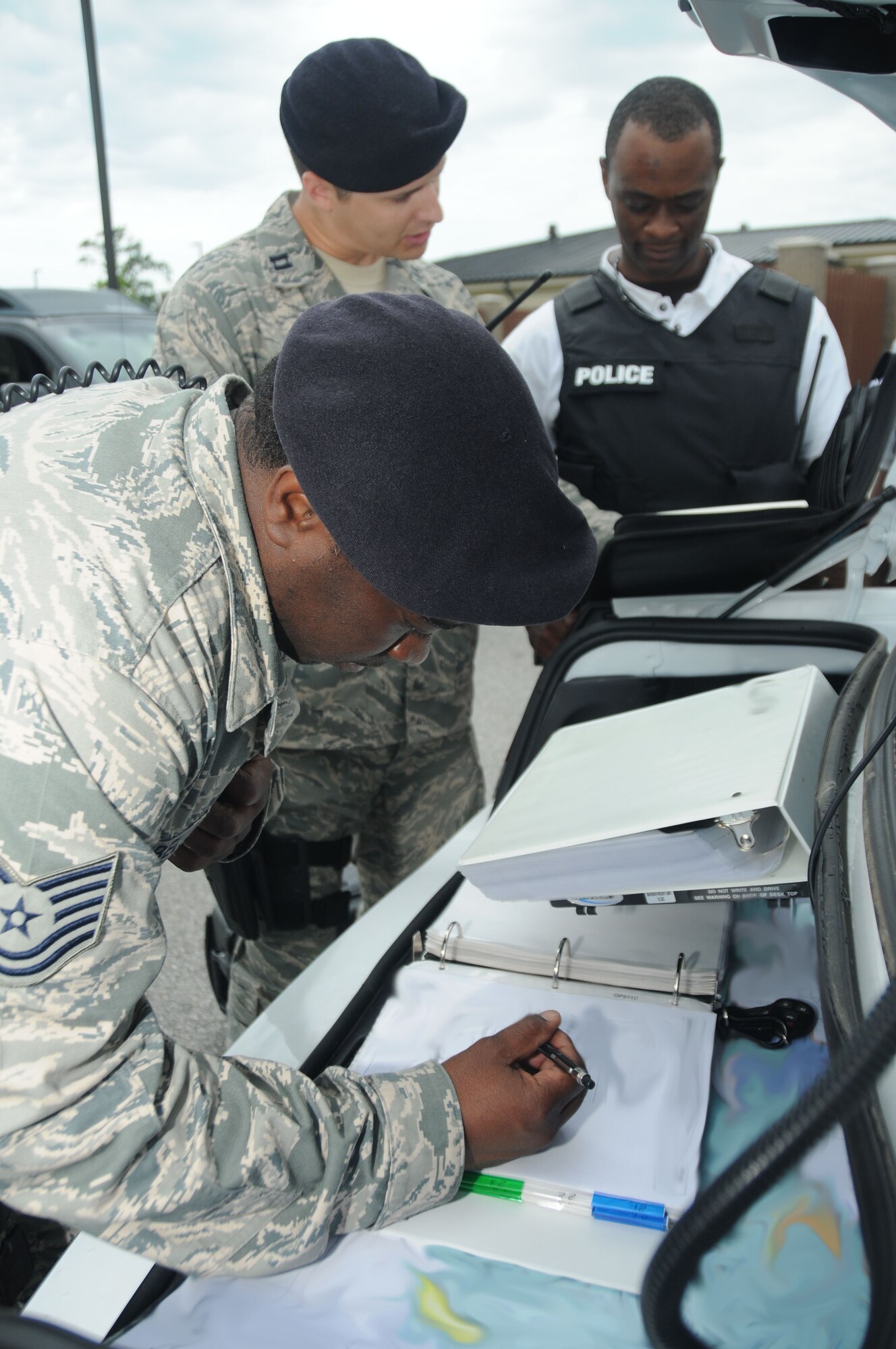 Tech. Sgt. Phillip Belle, Capt. Christopher Porta and Investigator Jakavious Pickett, 81st Security Forces Squadron, discuss the cordon area at the on scene command center’s command and control during Keesler's active shooter exercise, June 12, 2012, at the Arnold Annex, Keesler Air Force Base, Miss. The two-day exercise consisted of a lone gunman opening fire with four people killed and 32 injured. The exercise tested the base's ability to respond and recover from a mass casualty event. (U.S. Air Force photo by Kemberly Groue)