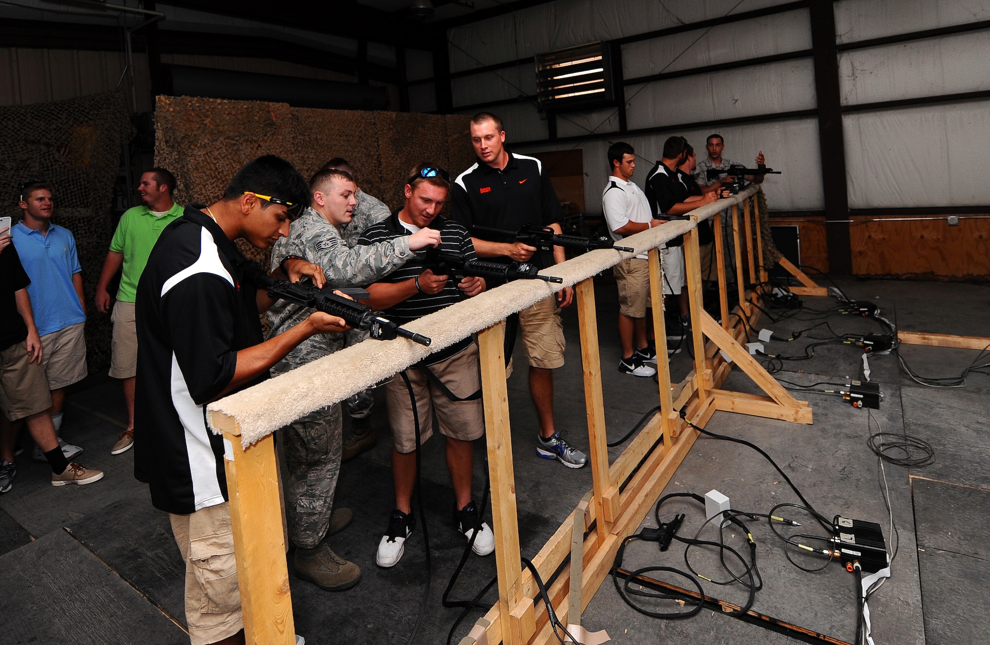 Baseball players from the University of Florida receive instruction on how to properly operate M-9 and M-4s by 55th Security Forces Squadron personnel in the simulator during their tour of the 55th Wing June 17 at Offutt Air Force Base, Neb.  The 55th Wing sponsors a College World Series baseball team every year.  (U.S. Air Force photo by Josh Plueger)